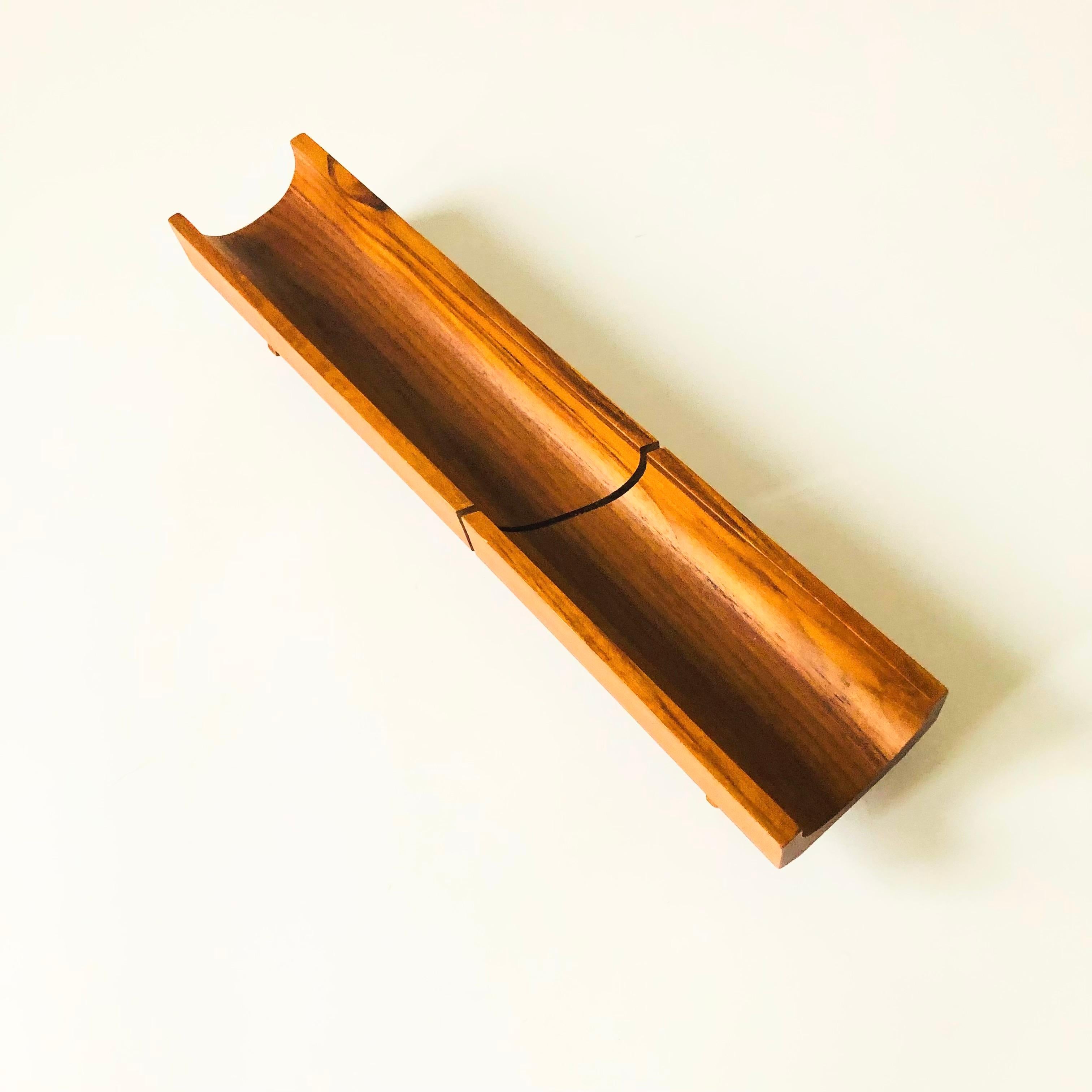 A vintage teak bread cutting board by Selandia. Curved shape for holding a piece of bread in place with an angled groove in the center for guiding a knife. Beautiful natural grain to the wood.

