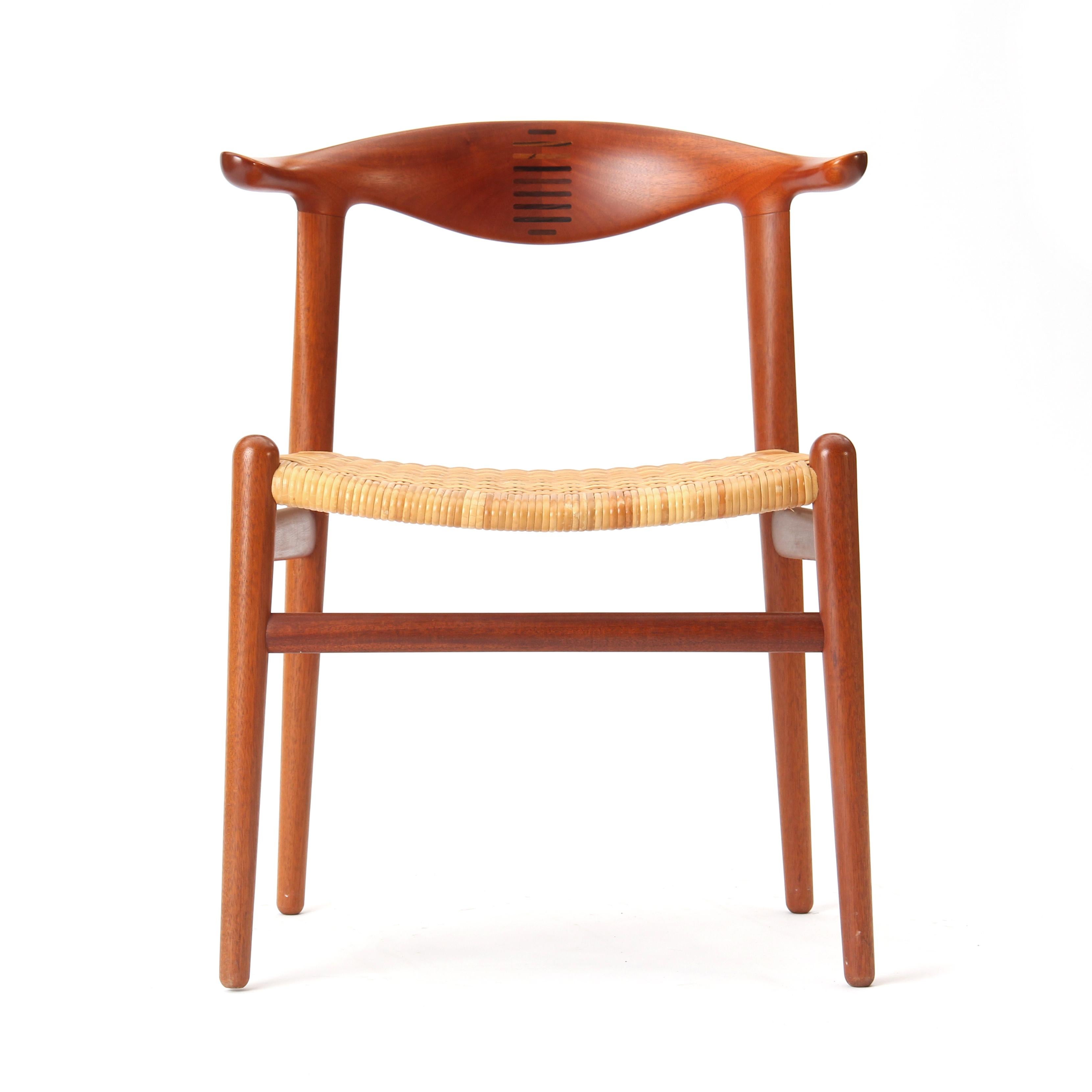 Une rare chaise de salle à manger moderne danoise en teck avec un dossier cannelé et un siège en canne naturelle. Le modèle JH-505 a été conçu en 1952 par Hans J. Wegner et produit dans les années 1960 par Johannes Hansen.