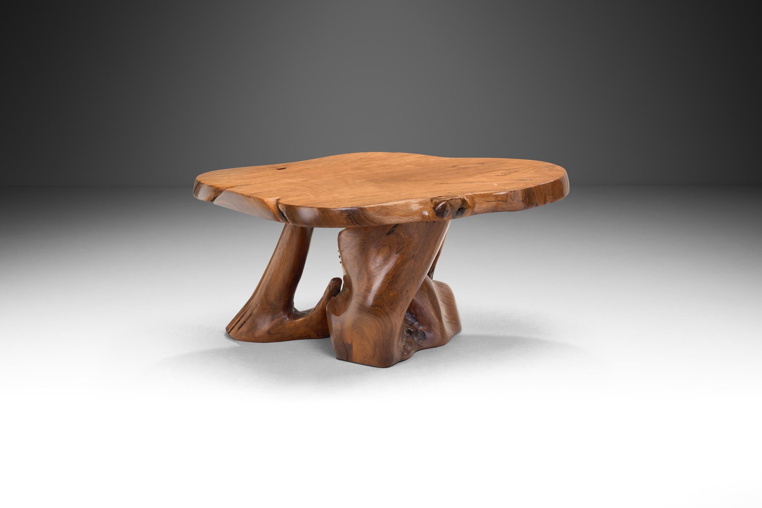 Inspired by the beauty of the natural root form, this organic teak coffee table is handcrafted from one piece of teak root. The root is painstakingly unearthed. The surface is sanded and polished while preserving the material’s gorgeous, original
