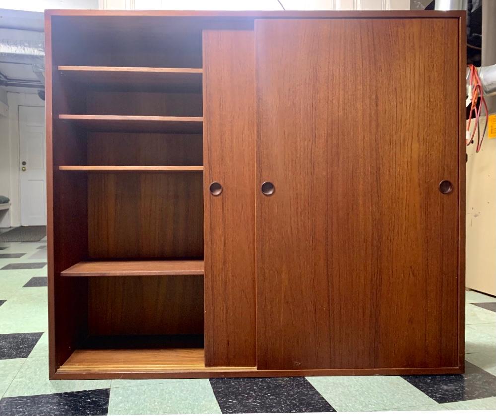 Mid century teak cabinet with sliding doors designed by Borge Mogensen for Karl Andersson and made in Sweden in the mid-60's. Originally sold by Georg Jensen. Cabinet is in very good condition and has six interior solid teak, adjustable