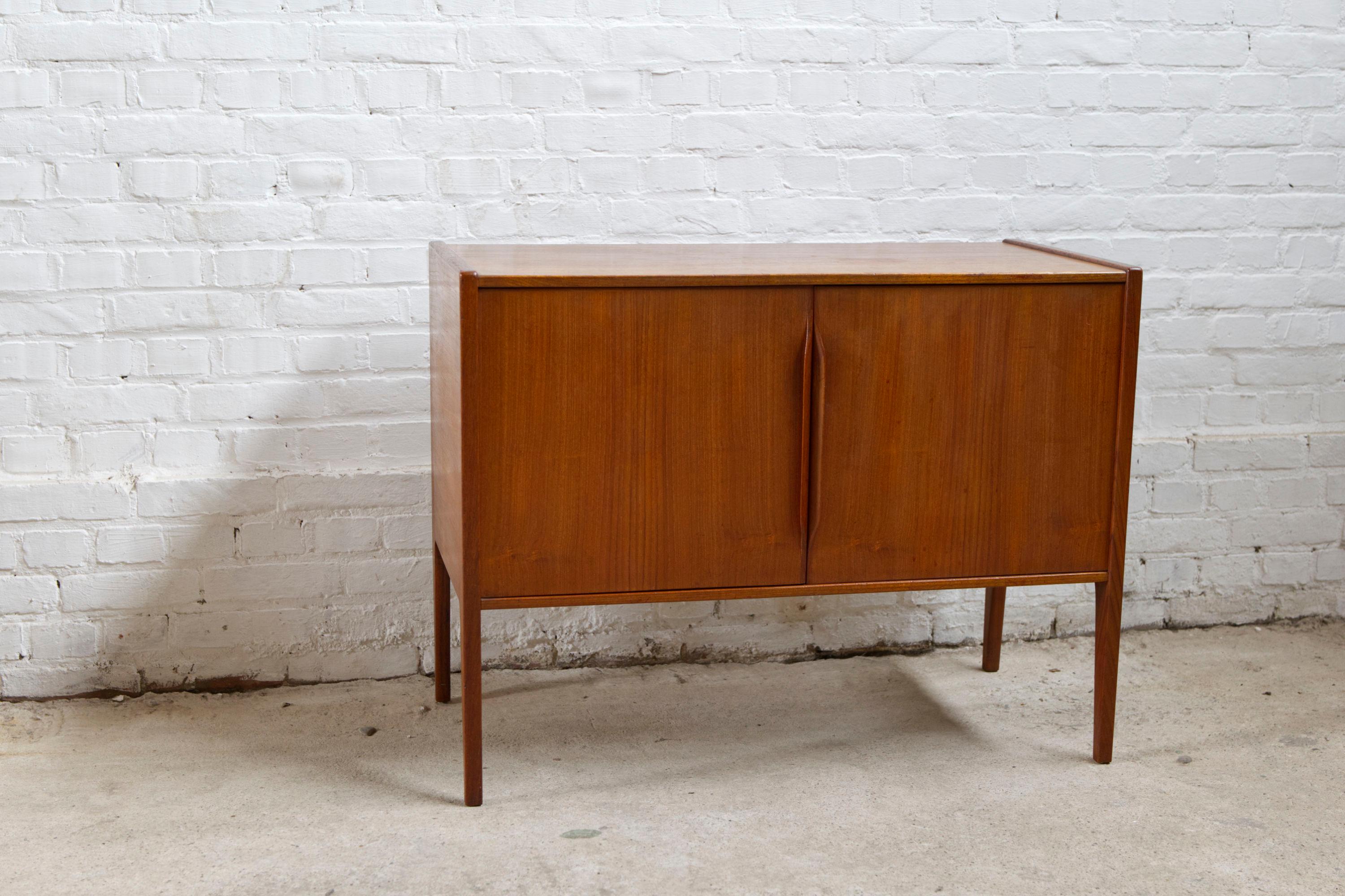 This small cabinet designed by Kai Kristiansen and manufactured by Aksel Kjersgaard in Denmark in the 1960s. This model 34 is very rare and a great example of the top quality Aksel Kjersgaard produced for Kai Kristiansen. The legs continuing up the