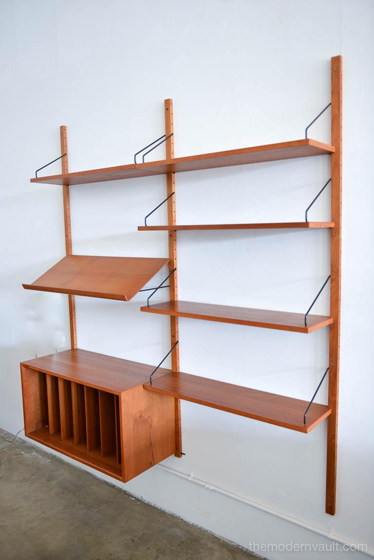 Teak cado royal wall system by Poul Cadovius, circa 1965. Wall Unit includes two bays, as shown with five shelves, slanted magazine rack and slatted organization cabinet. Includes all shelving brackets as shown. Excellent vintage condition with only