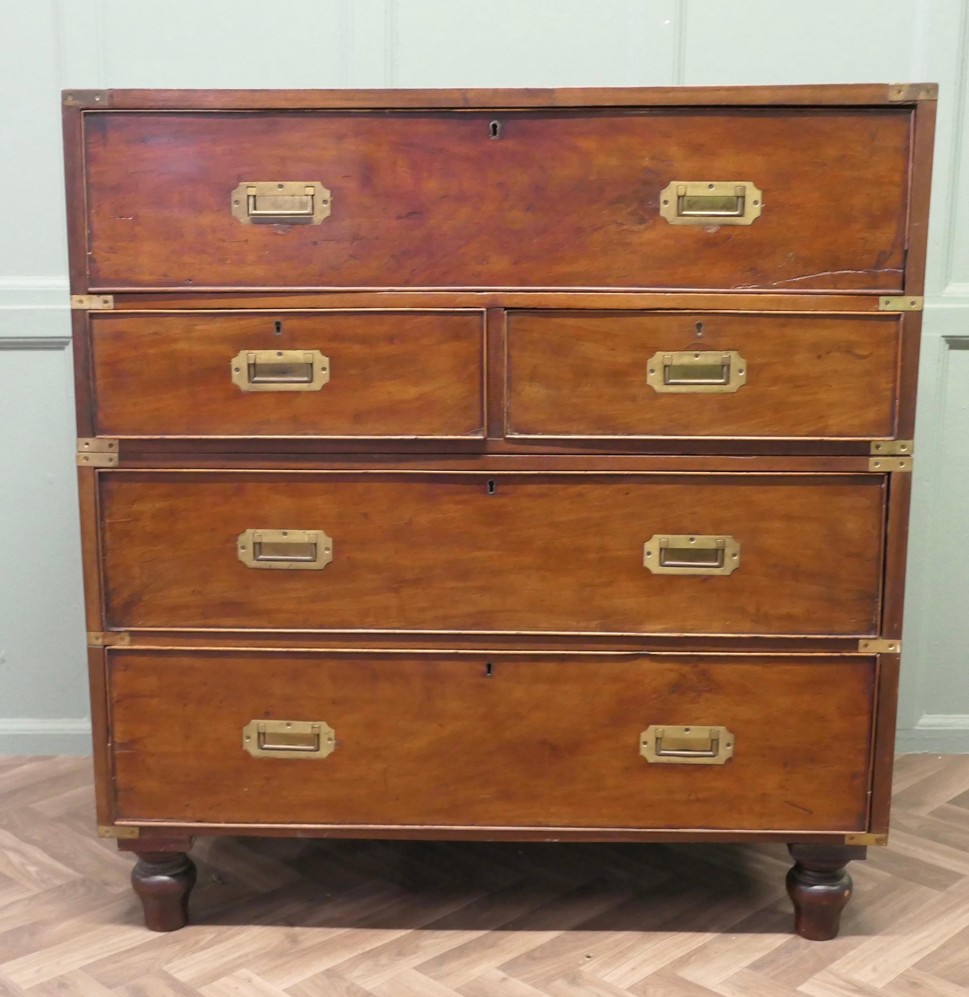 Teak Campaign Chest, 2 Piece Secretaire 

This is a delightful piece, it is made in Teak with campaign style brass corners and inset brass handles on the front and carrying handles to the sides
The chest has a fully fitted bureau in the top drawer,