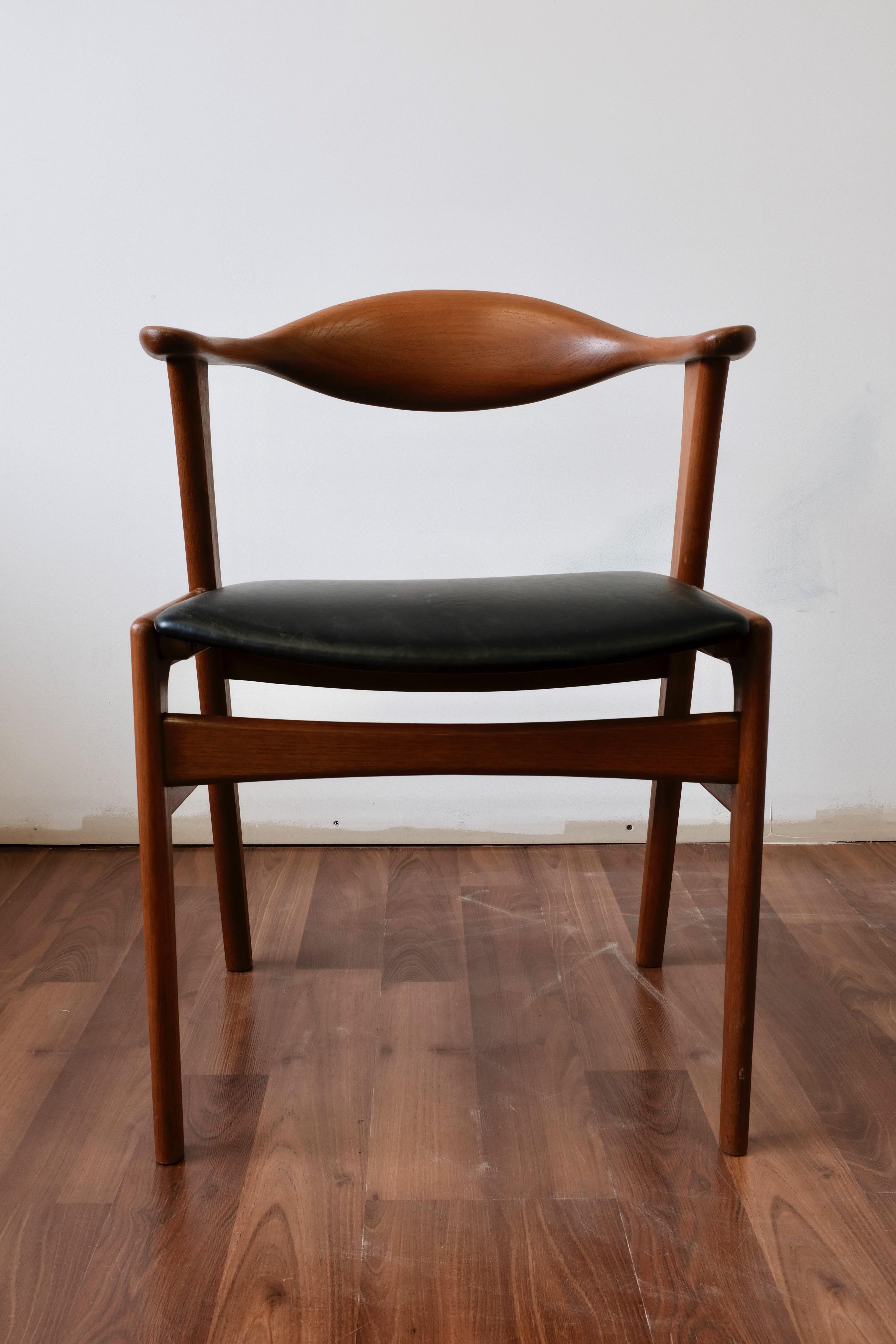 Teak dining or side chair designed by Erik Kirkegaard and made in Denmark by Hong Stolfabrik.

The chair frame is solid teak and features a distinctive sculptural backrest that curves forward to provide support for the elbows. The frame has been