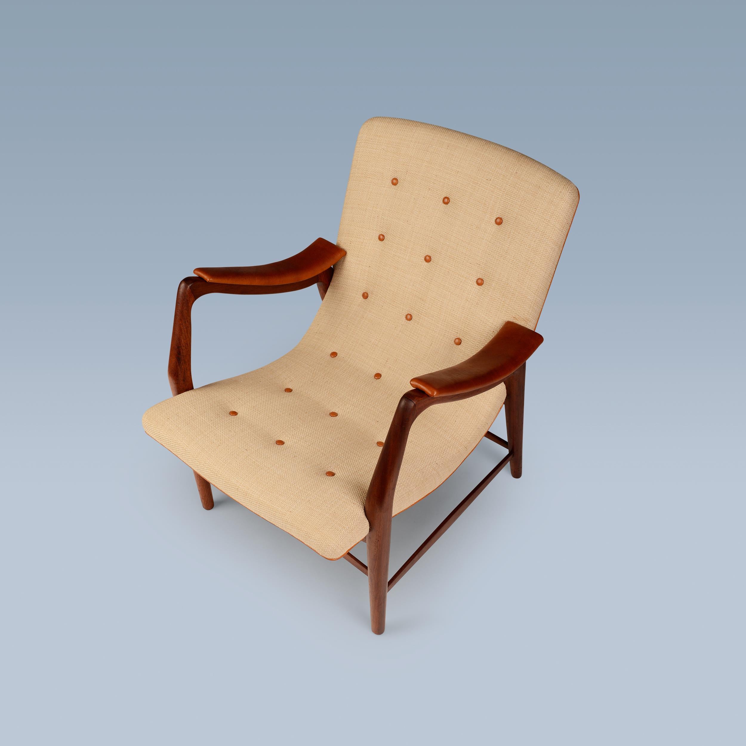 Dieser seltene Sessel aus Teakholz hat eine geschwungene Sitzfläche und die Rückenlehne ist mit hellem Stoff gepolstert. Die Armlehnen, die Keder und die Knöpfe auf der Rückseite sind mit Nigerleder ausgestattet.

Der Stuhl wurde Anfang 1947 von