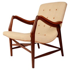 Chaise en teck avec assise incurvée recouverte de tissu clair et de détails en cuir.