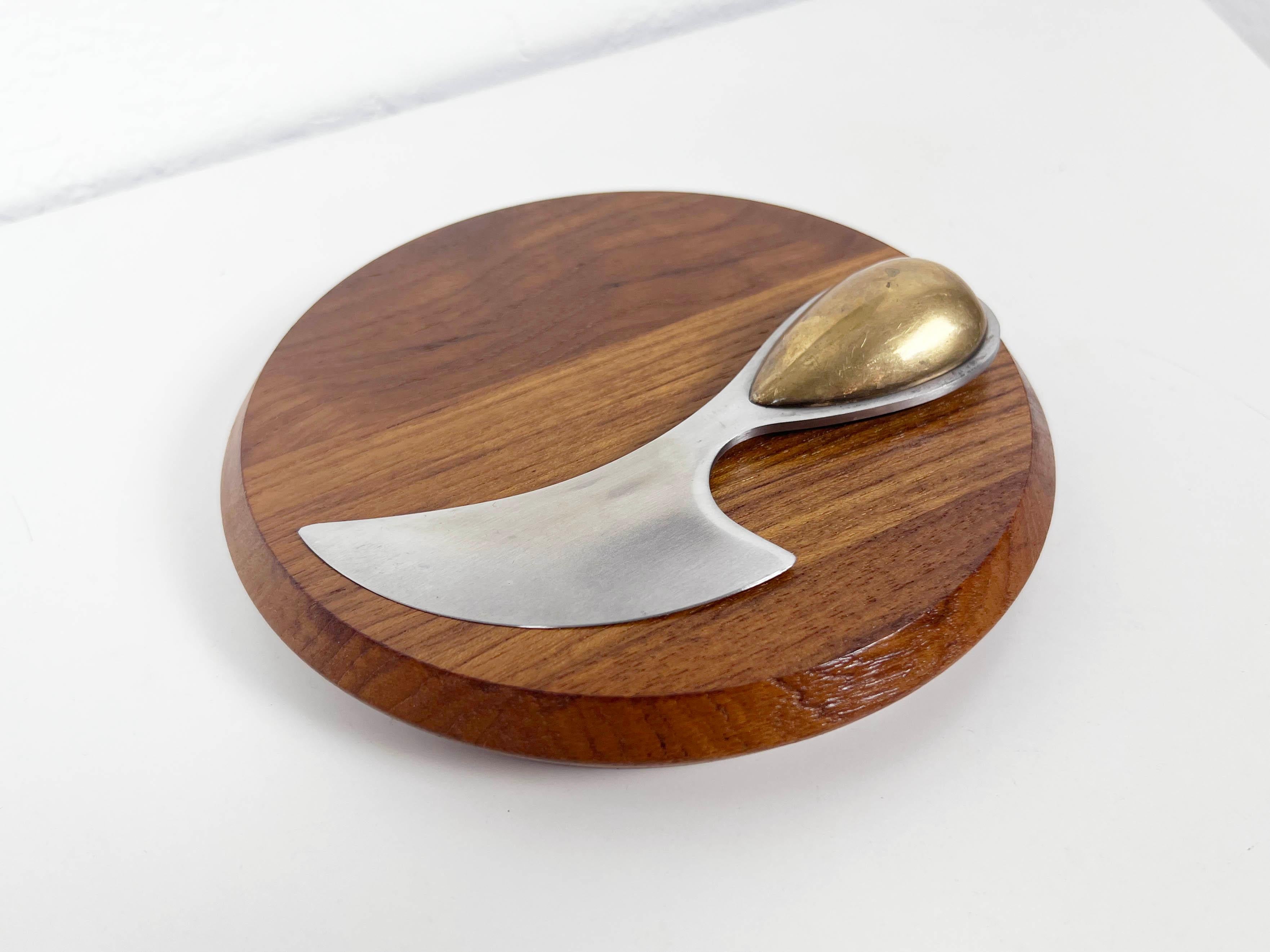 Vintage teak cheese board with stainless steel and brass knife designed by master jewelry maker Vivianna Torun for Dansk. 

Designer: Vivianna Torun Bülow-Hübe

Manufacturer: Dansk

Year: 1960s

Style: Mid Century Modern / Danish Modern /