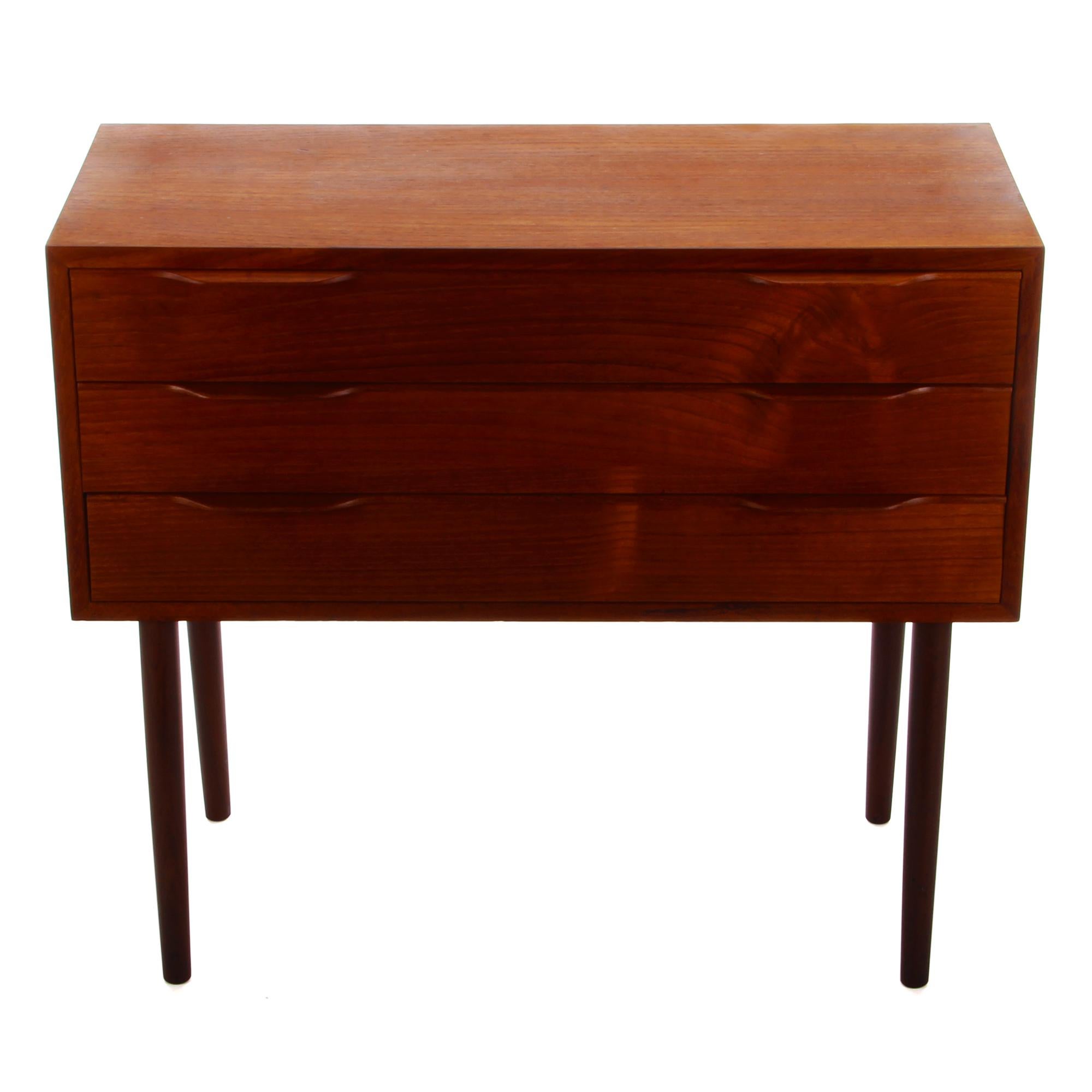 Teak chest of drawers from the 1960s - Danish vintage entry table or dresser with three drawers - in good vintage condition.

A beautiful midcentury dresser with teak veneer on all surfaces. Four long legs carry a rectangular shaped body with