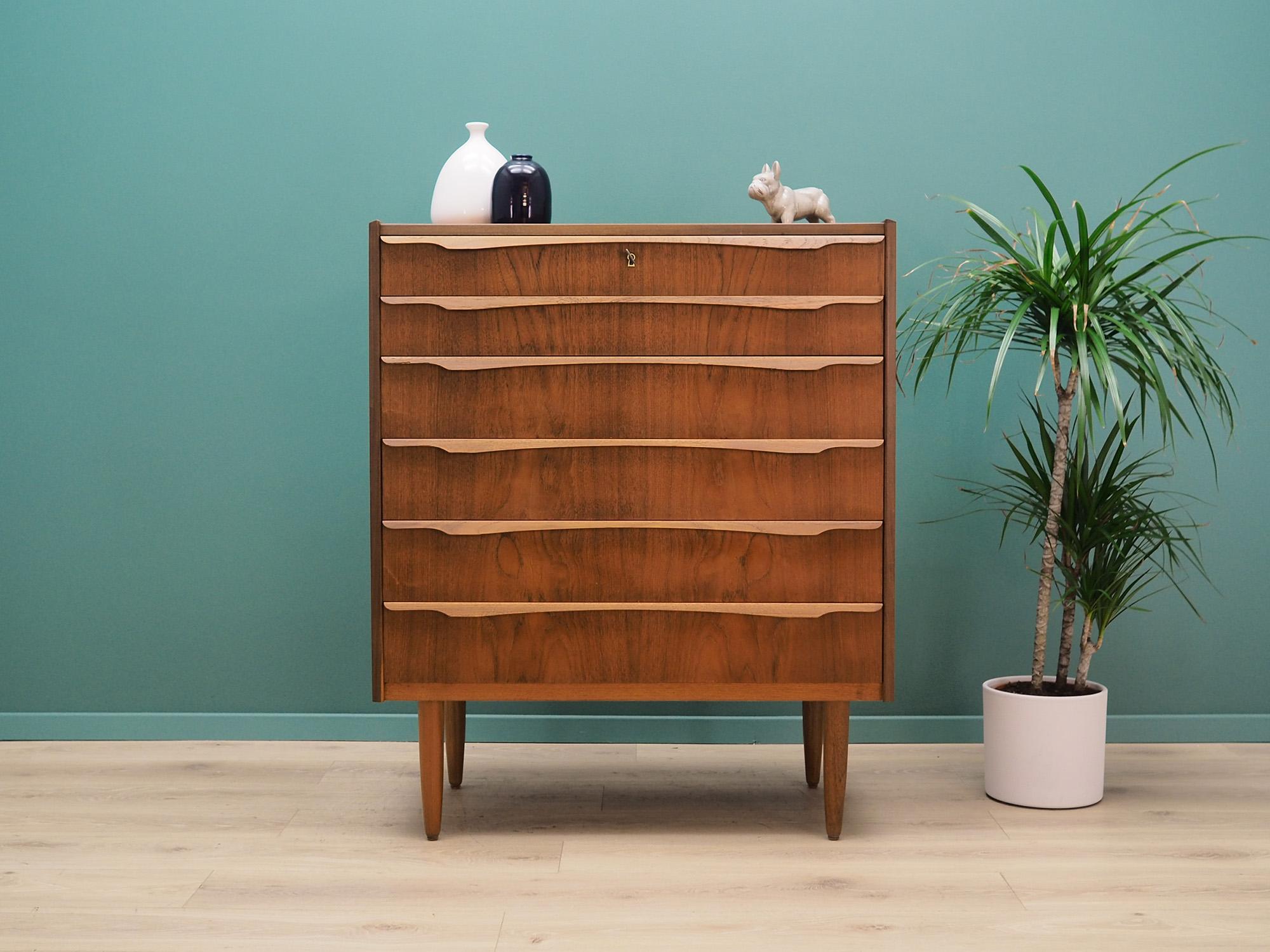 Fantastic chest of drawers from the 60 / 70's. Danish design, minimalist form. Surface of the furniture is covered with teak veneer, legs are made of solid teak wood. Furniture has six stylish drawers, a key included. Preserved in good condition