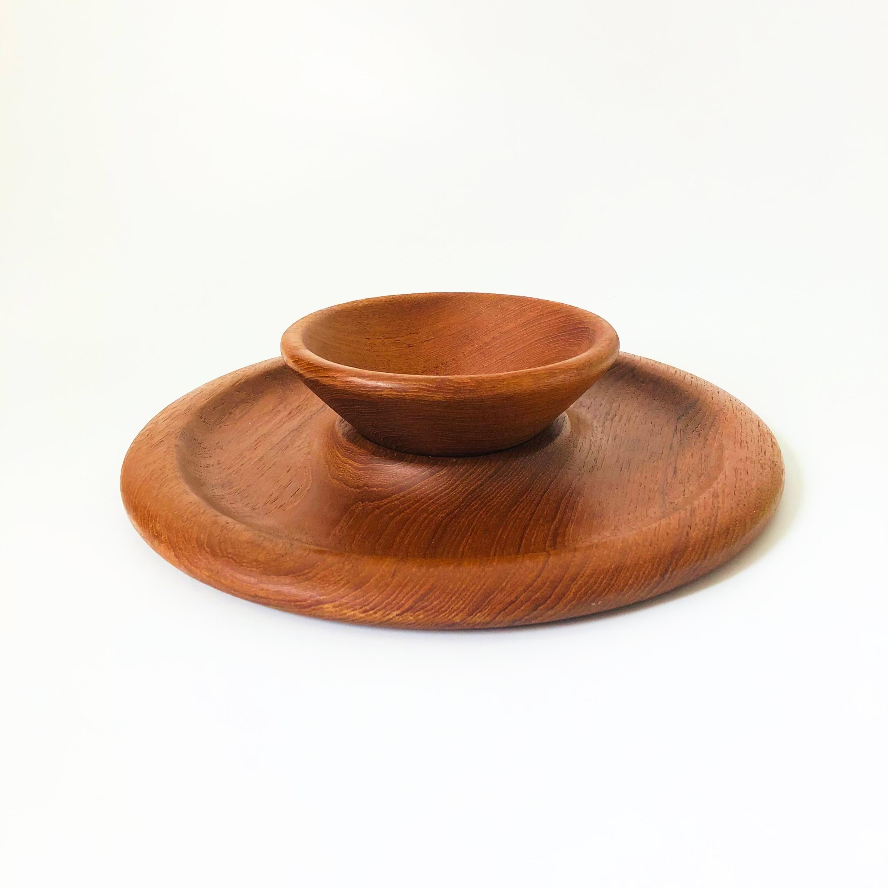 A vintage teak chip and dip tray. Includes a smaller removable bowl in the center. Raised rim along the edge for keeping things in places. Beautiful natural grain to the wood.
Measurements:
Overall: 12