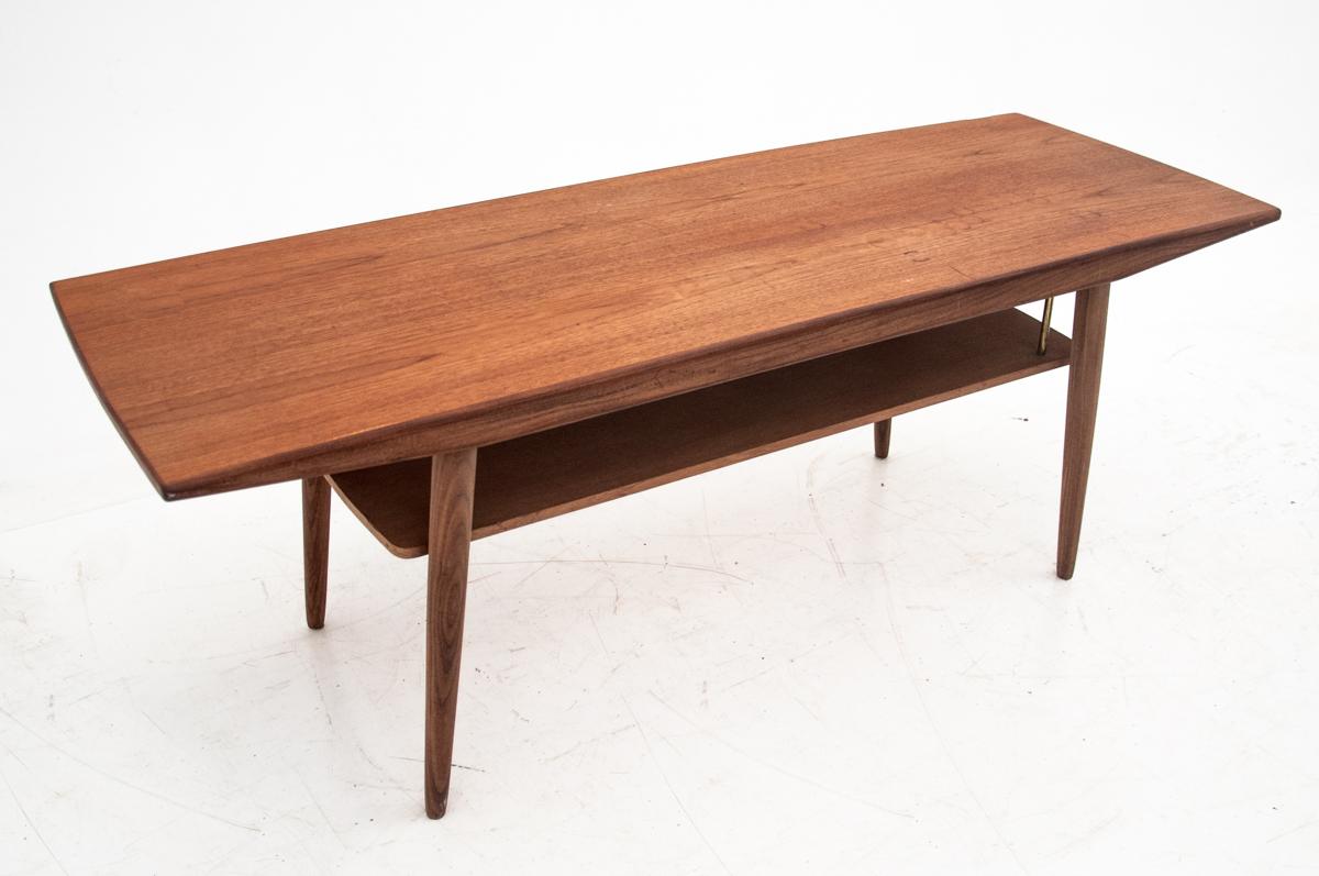 Teak coffee table comes from Denmark from the 1960s. There is an additional shelf under the counter. Preserved in very good condition.