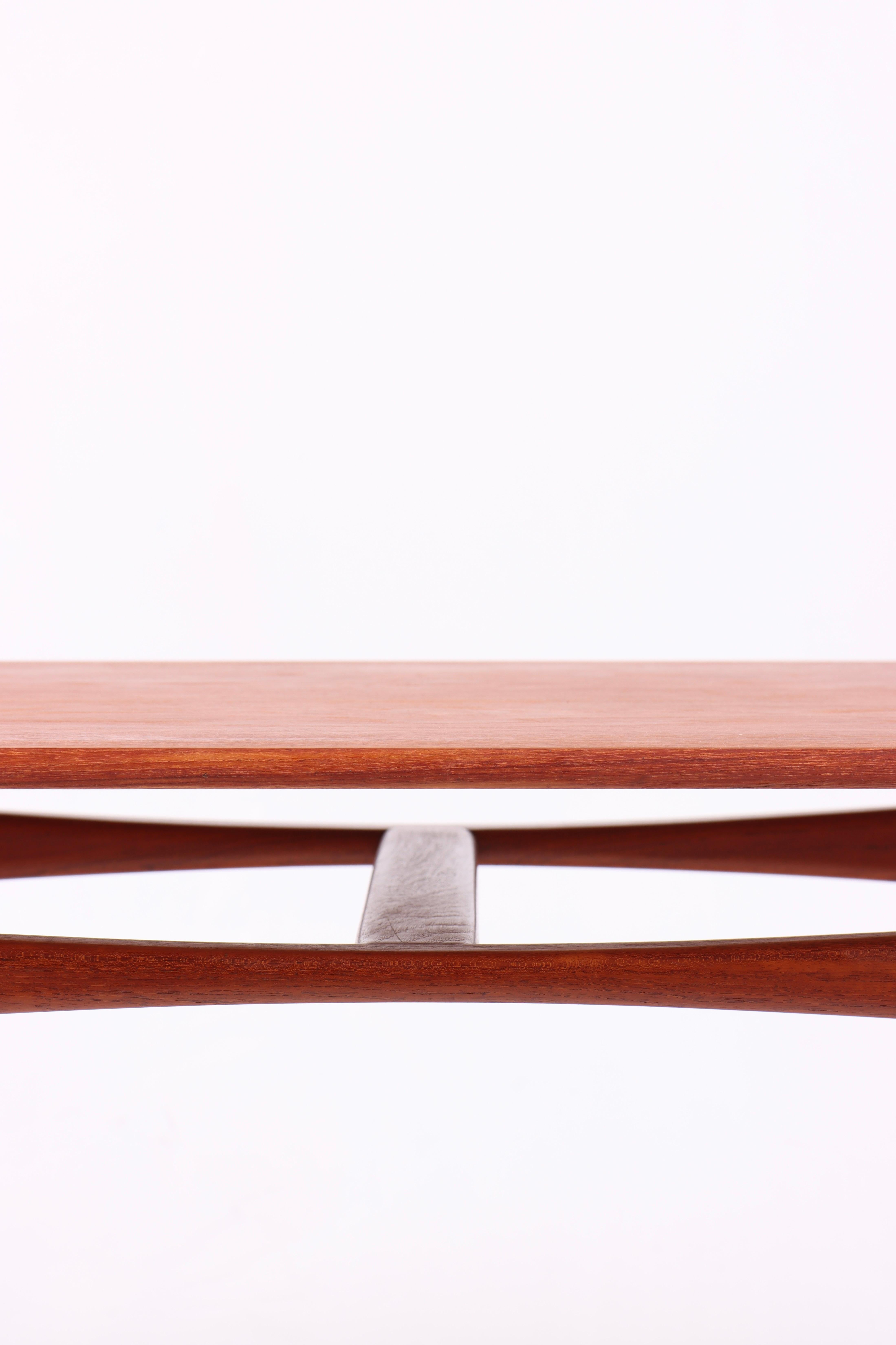 Élégante table basse danoise du milieu du siècle, conçue par Ejnar Larsen et Aksel Bender Madsen pour le maître ébéniste Willy Beck dans les années 1950. La table est réalisée en teck magnifiquement grainé, avec un cadre solide finement travaillé et