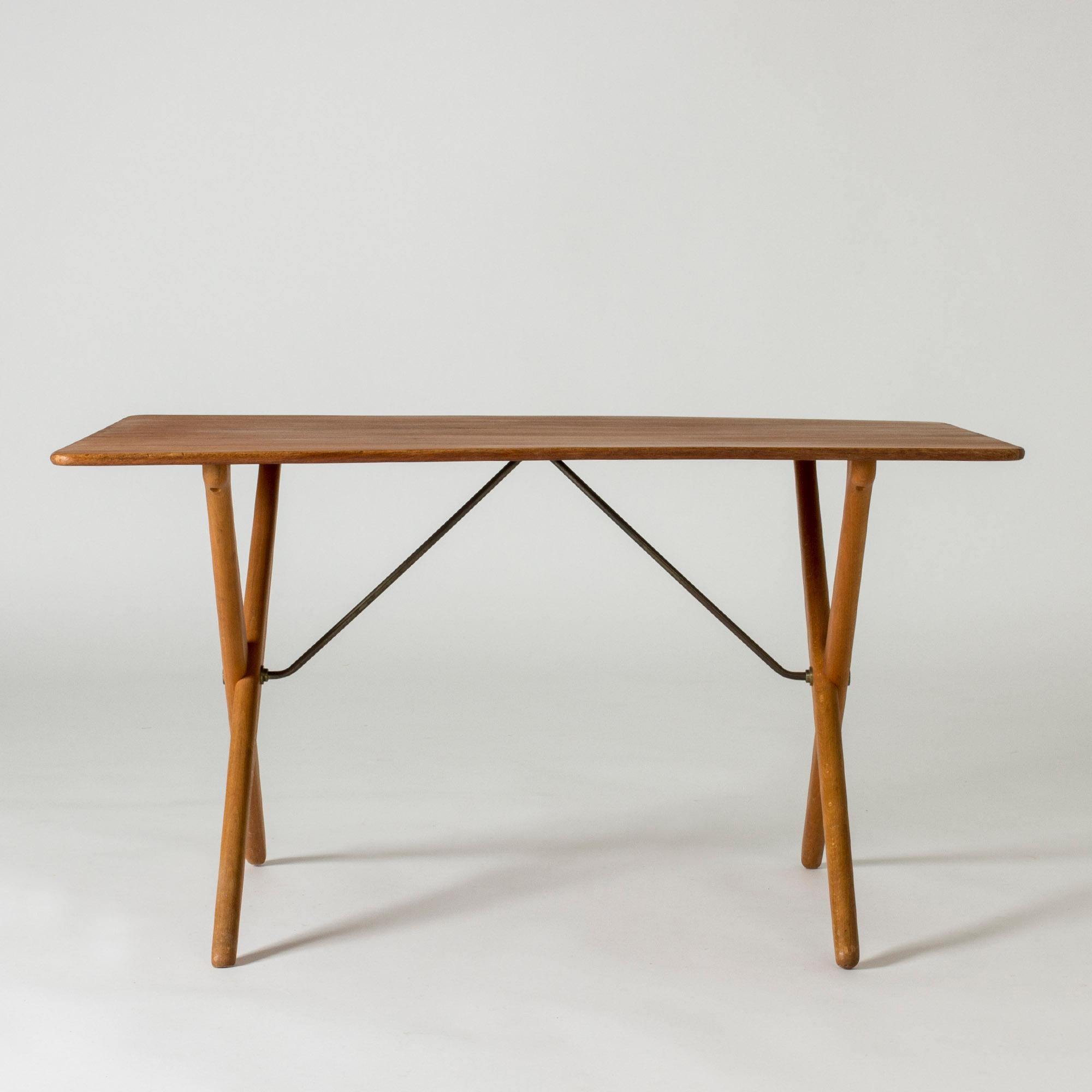 Coffee table “AT 308” by Hans J. Wegner, with a teak table top and oak legs. Elegantly sculpted, crossed legs, brass extenders.