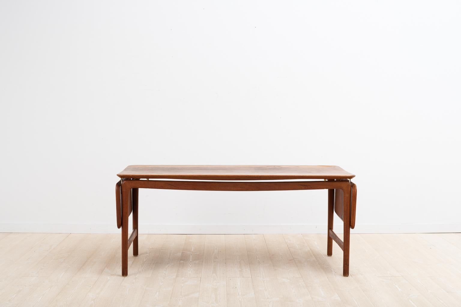 Teak coffee table designed by Peter Hvidt & Orla Mølgaard Nielsen for France & Daverkosen. The table is manufactured from solid teak. The middle part is 128 cm and the side panels ca 25 cm each.

The table top has some minor scraped and a small