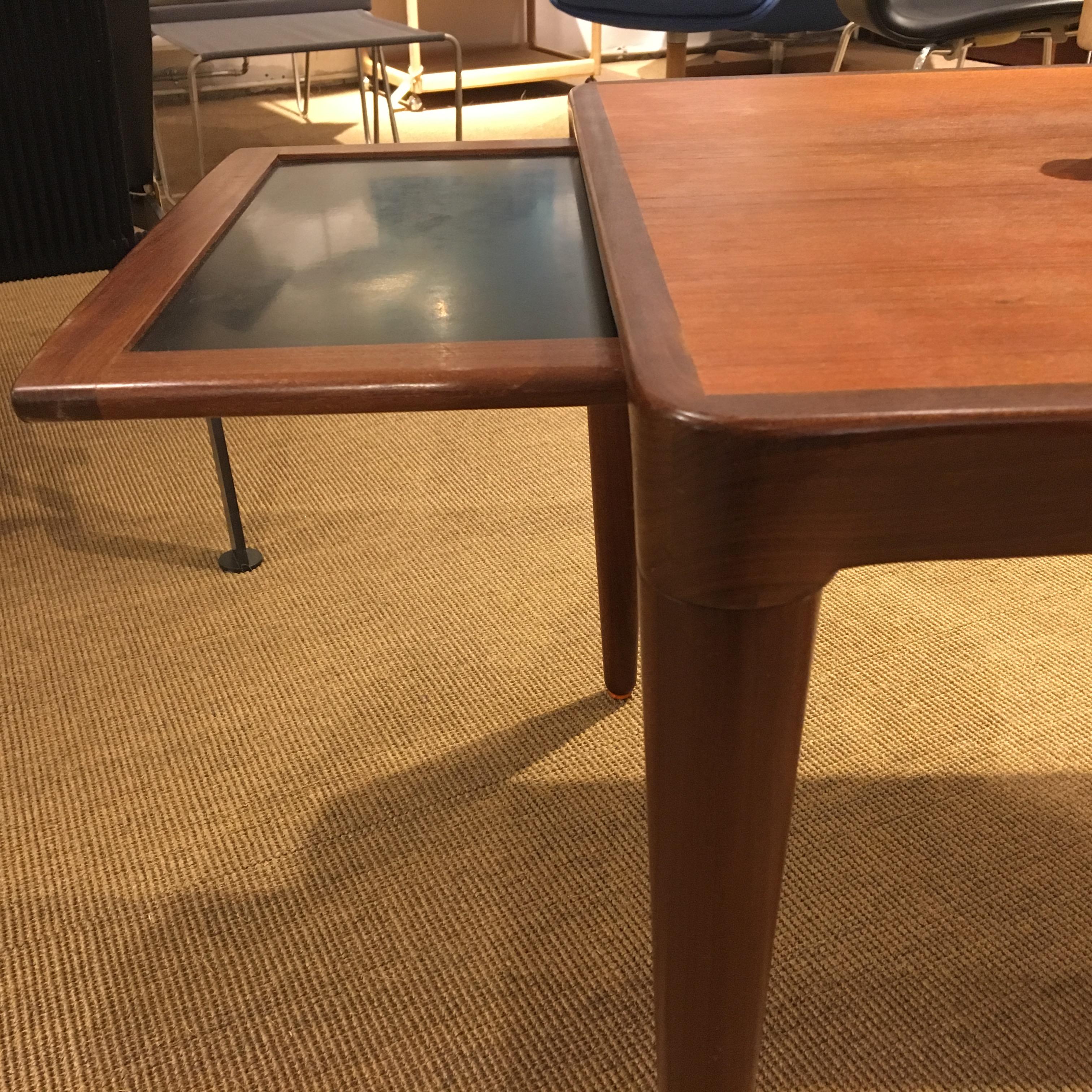 Teak coffee table from B.C. Møbler Vejle, 1950s. 
Teak coffee table with round tapered legs and Fine round corners to fit the legs.
Has a small Fine Formica pull-out plate for placing the hot coffee pot on.
Dimensions: 165 x 60 x 50 cm
Produced
