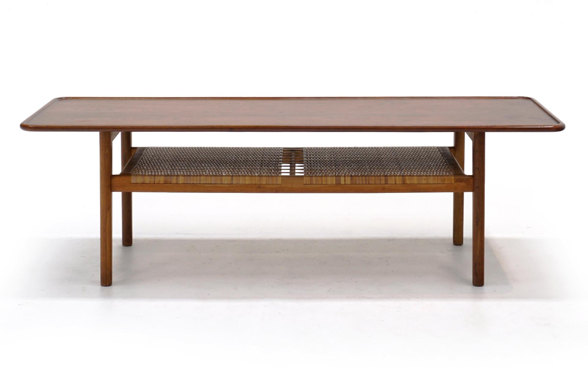 Hans Wegner teak and cane coffee table in completely original condition. Produced by Adreas Tuck, Denmark, 1950s. This is a fine all original example of this design.