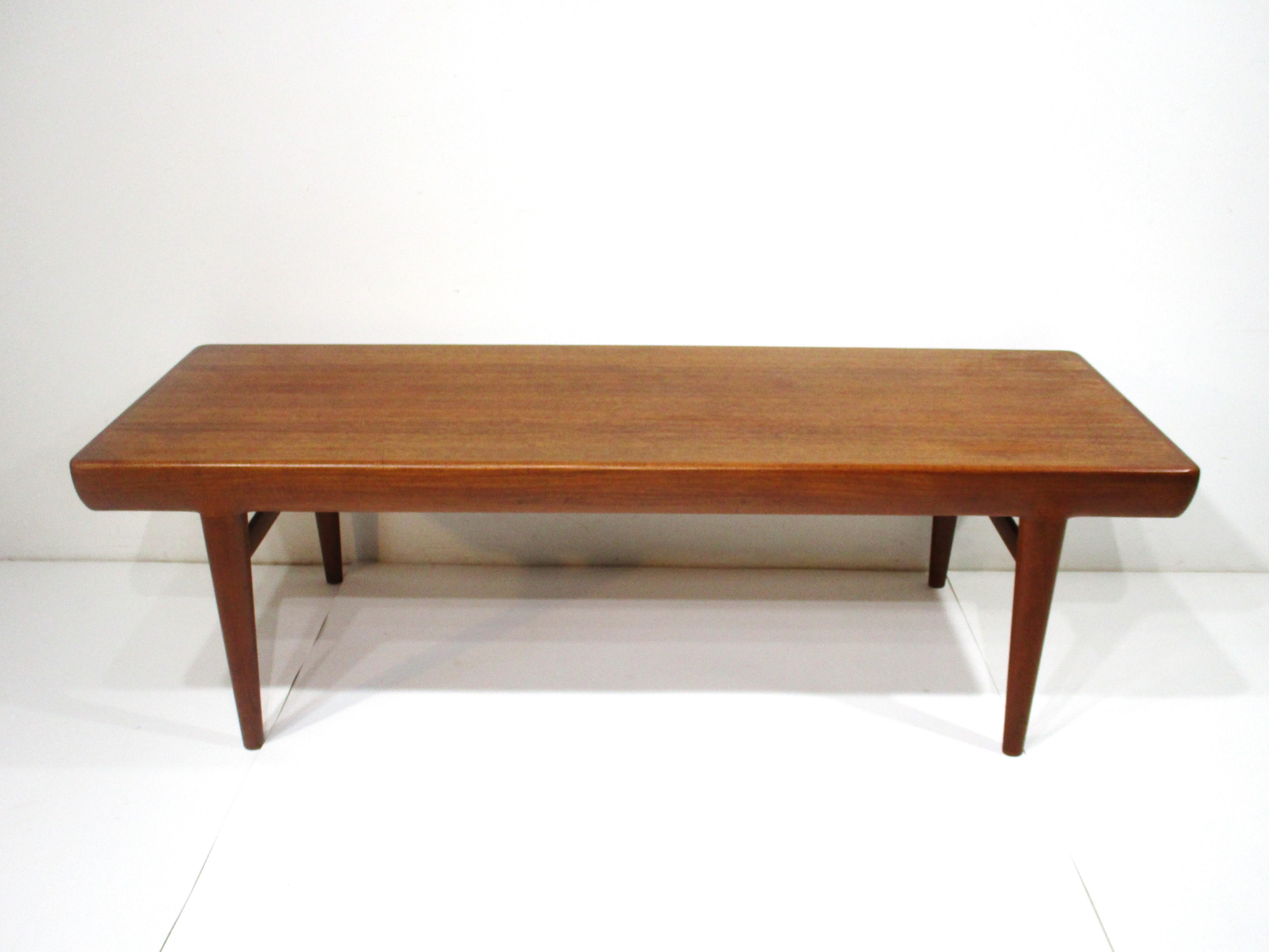 A very well made Danish modern teak wood coffee table with rare pull out end drawers . One side is a drawer with storage and the other end has black and white reversible covers over divided storage areas , just a nice design detail . The