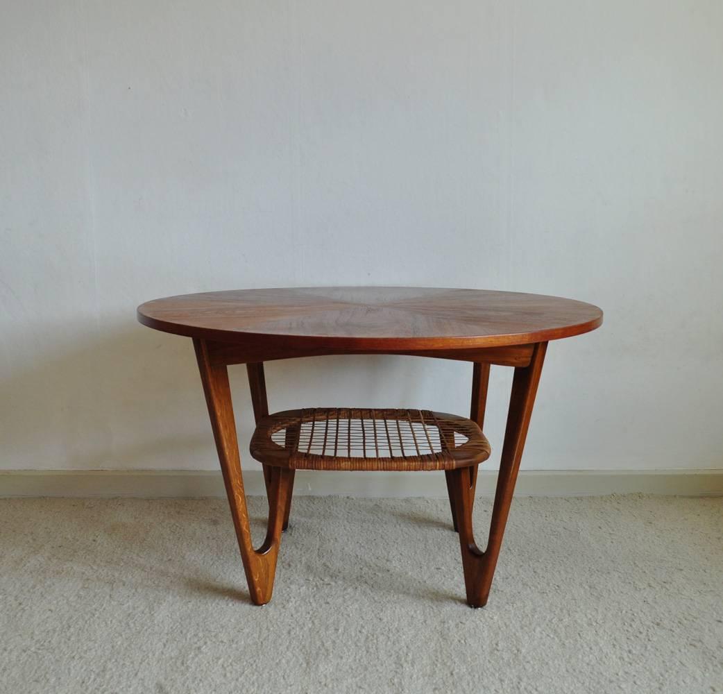 Magnificent and rare Danish modern coffee table with V-shaped legs by Kurt Østervig. The table top is crafted in teak and supported by rounded, V-shaped legs in oak. The caned rack beneath the surface is in a beautiful original condition.
Signs of