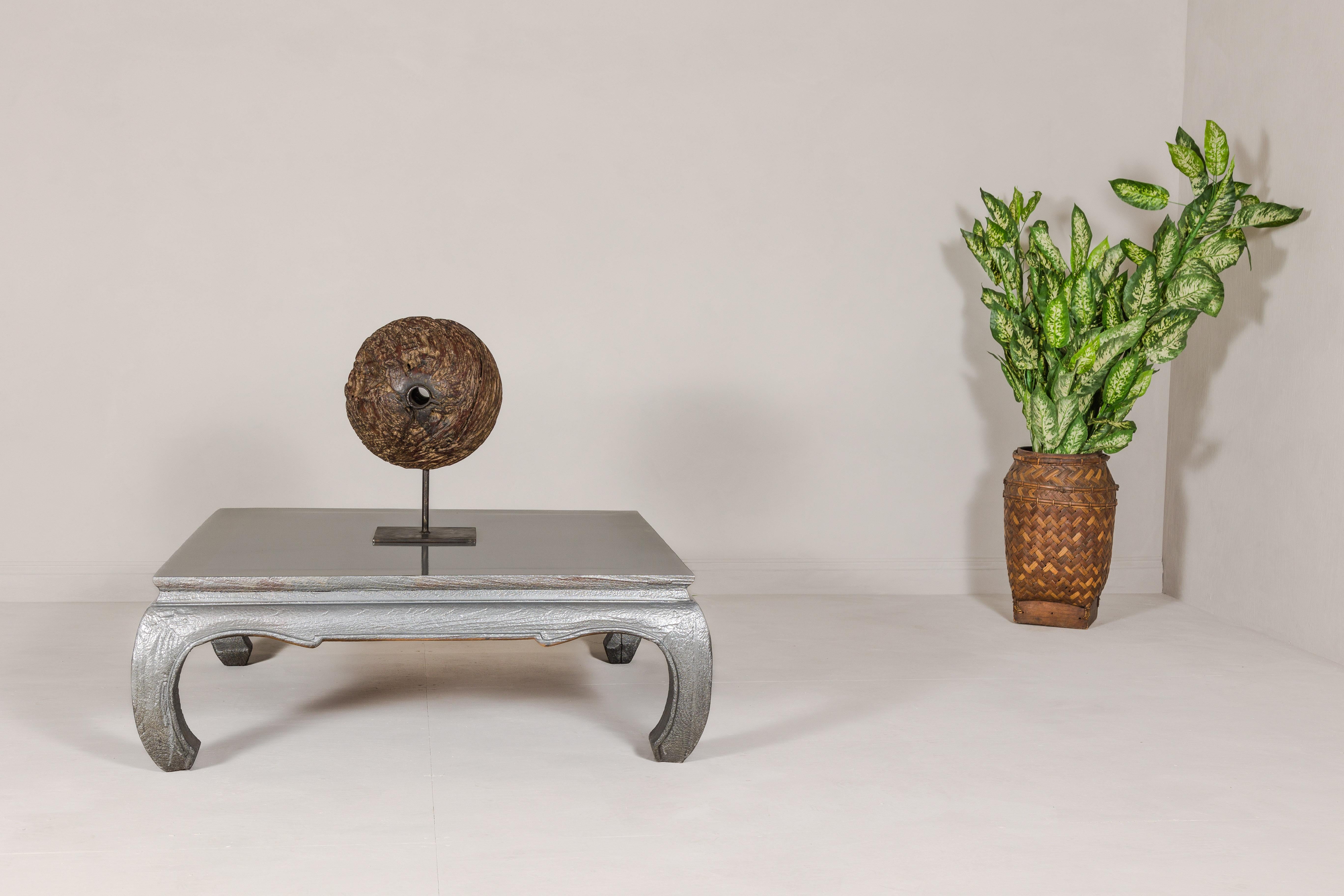 A vintage teak wood coffee table with custom silver patina, chow legs and carved apron on all sides. Introducing a vintage teak wood coffee table, a statement piece exuding timeless elegance with a touch of exotic charm. The table stands gracefully