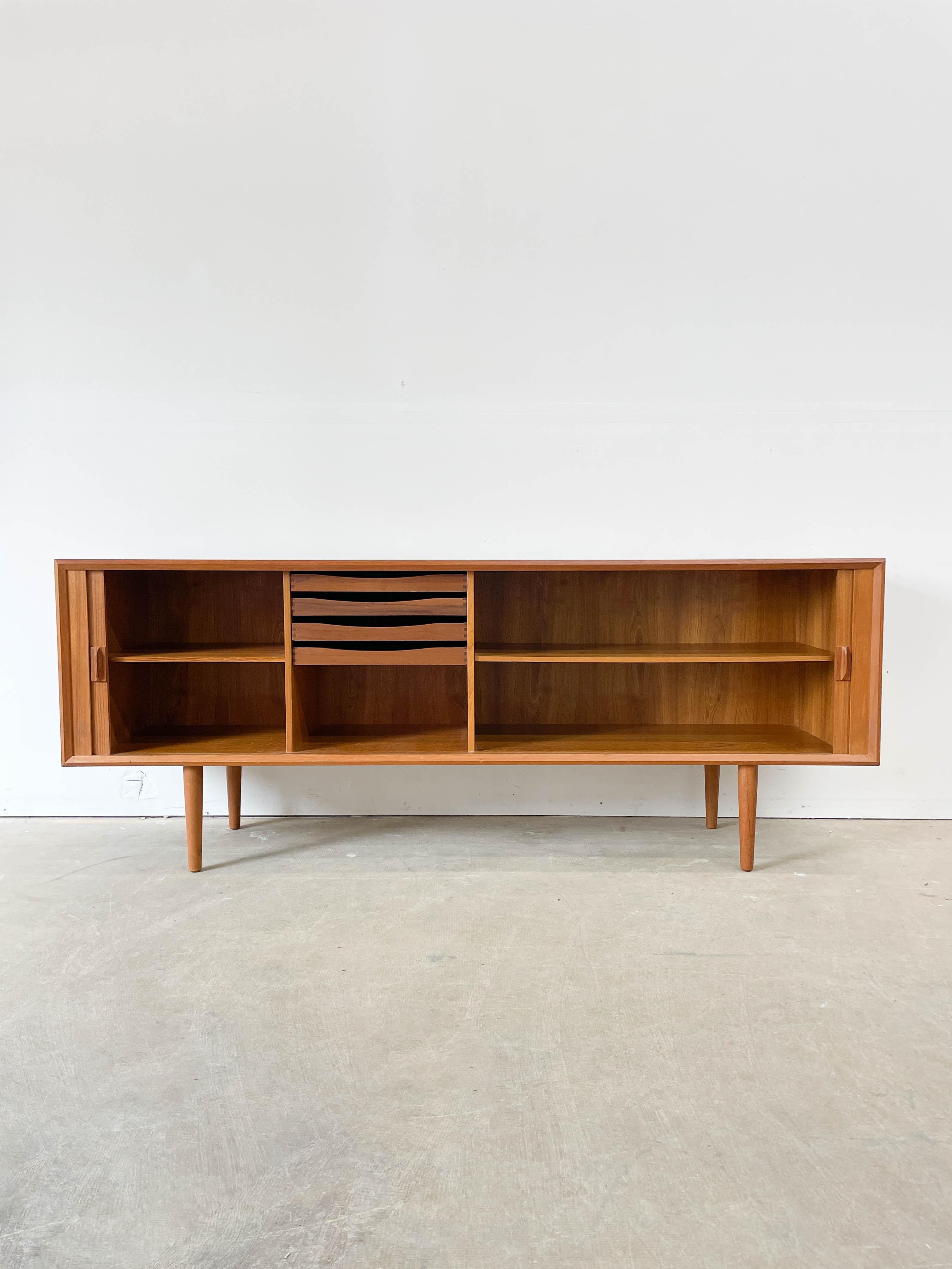 Stunning large teak credenza with tambour doors designed by Svend Larsen for Faarup Mobelfabrik in 1950s. Superb teak grain across the case but especially the doors and they slide effortlessly out of view. Excellent storage options with drawers and