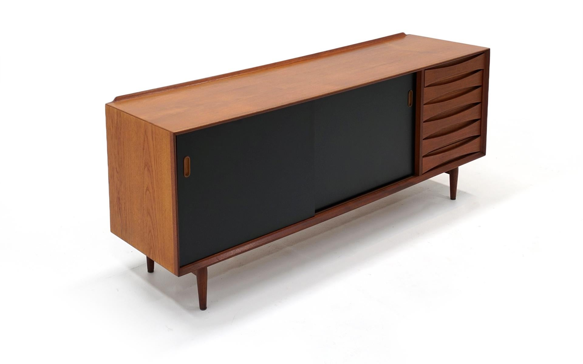 See the photos of this beautiful Danish modern teak credenza with reversible doors. Teak on one side, black lacquer on the other. An important sought after design by Arne Vodder for Sibast. Signed with the Sibast medallion.