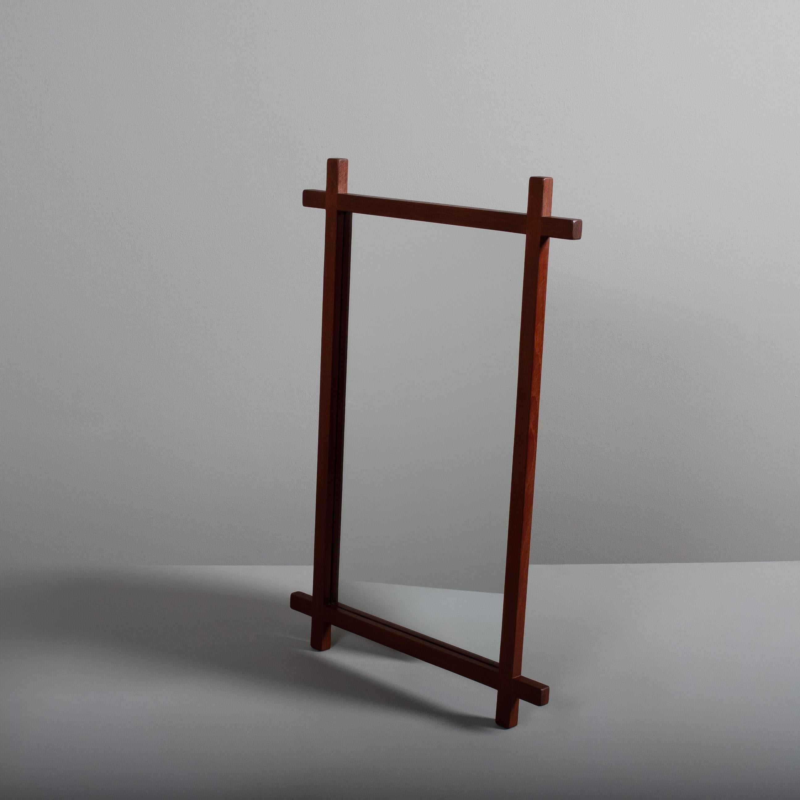 A very pleasing criss cross frame design on this 1950's modernist mirror. Clearly taking a minimised inspiration from much earlier Aesthetic and Arts & Crafts movement designs. 
Made from solid teak, Denamrk circa 1950. Original mirrored glass.