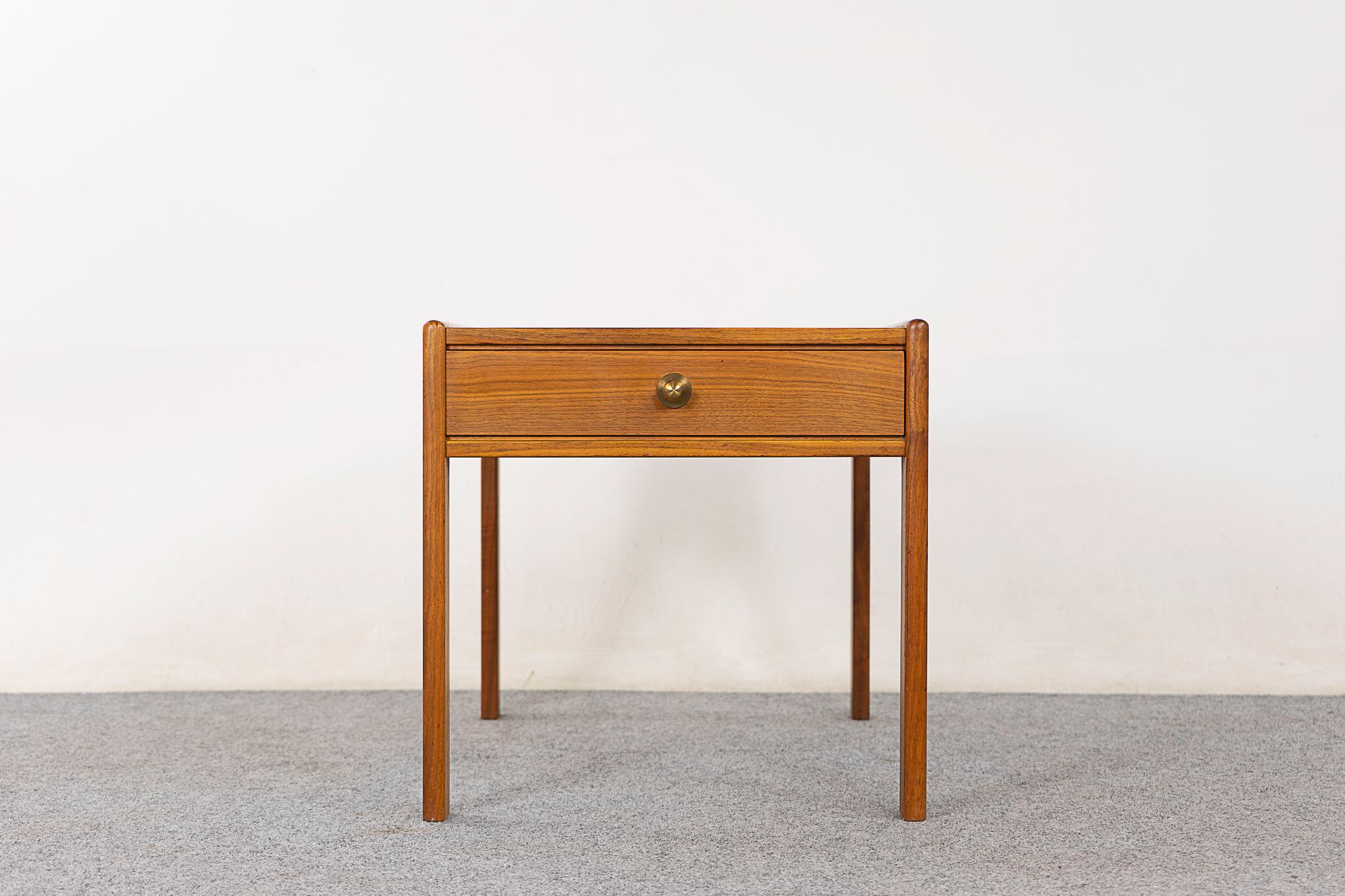 Teak mid-century bedside table, circa 1960's. Robust solid wood legs, handsome book-matched veneer on the top and drawer face, unique metal pull! 

Please inquire for remote and international shipping rates.