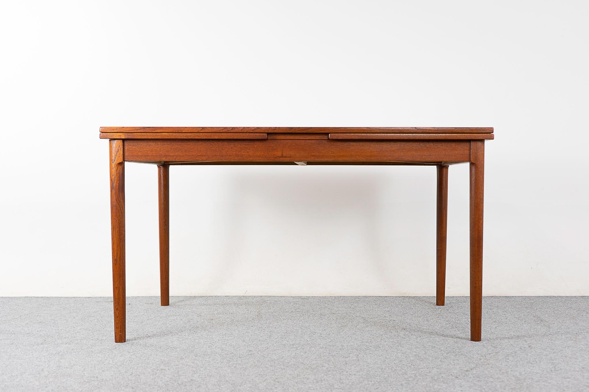 Teak mid-century draw leaf dining table, by Kai Winding circa 1960's. Beautiful quality table, top is framed in a generous solid wood edge, center boasts highly figured veneer. Leaves slide out from each end to expand the table surface by nearly two