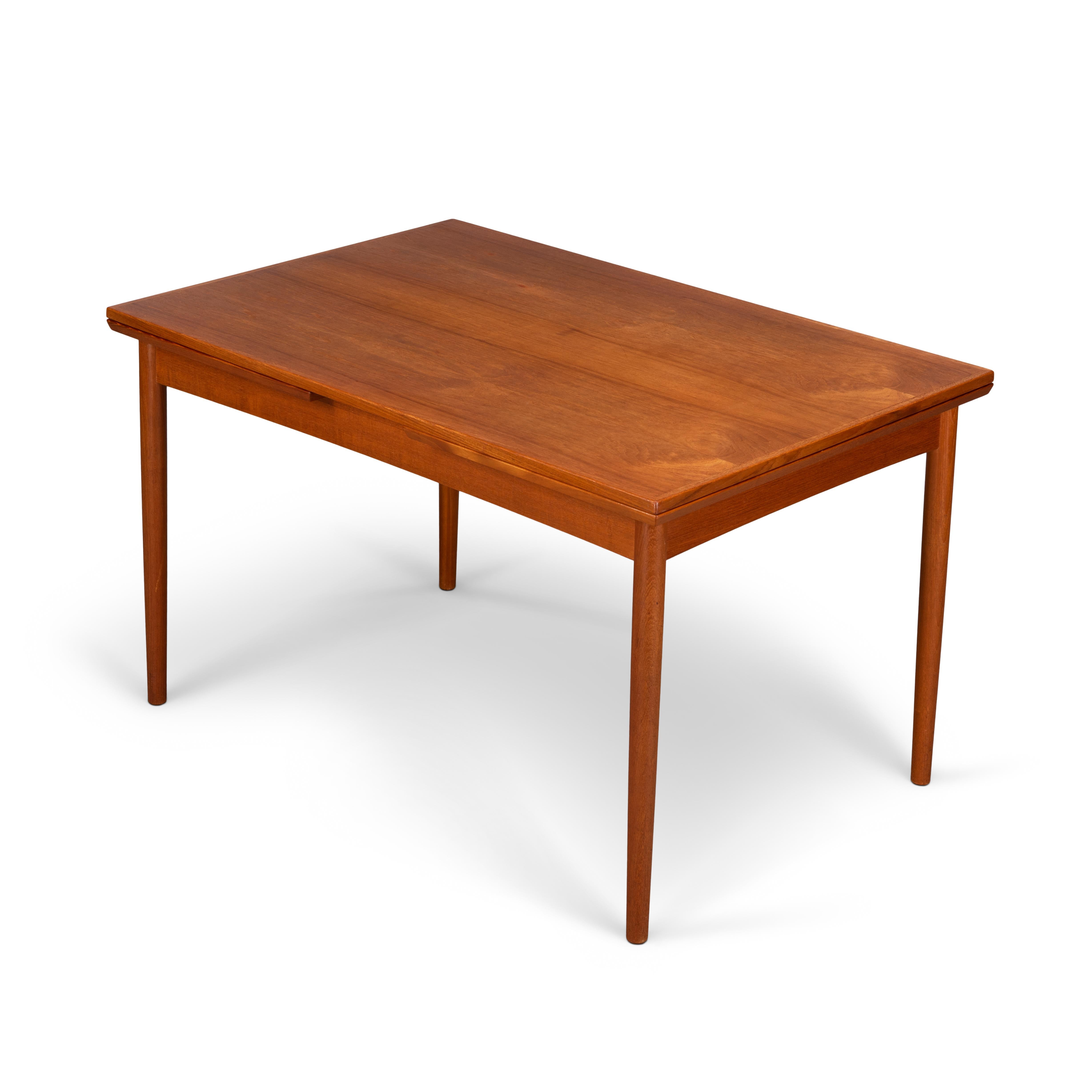 This Danish dining table was made in the 1960s. It features solid teak legs and two extensions leafs which each measures 52 cm and extends the table to 2.29 cm. The extension leafs are hidden underneath the top. De color still matches really well