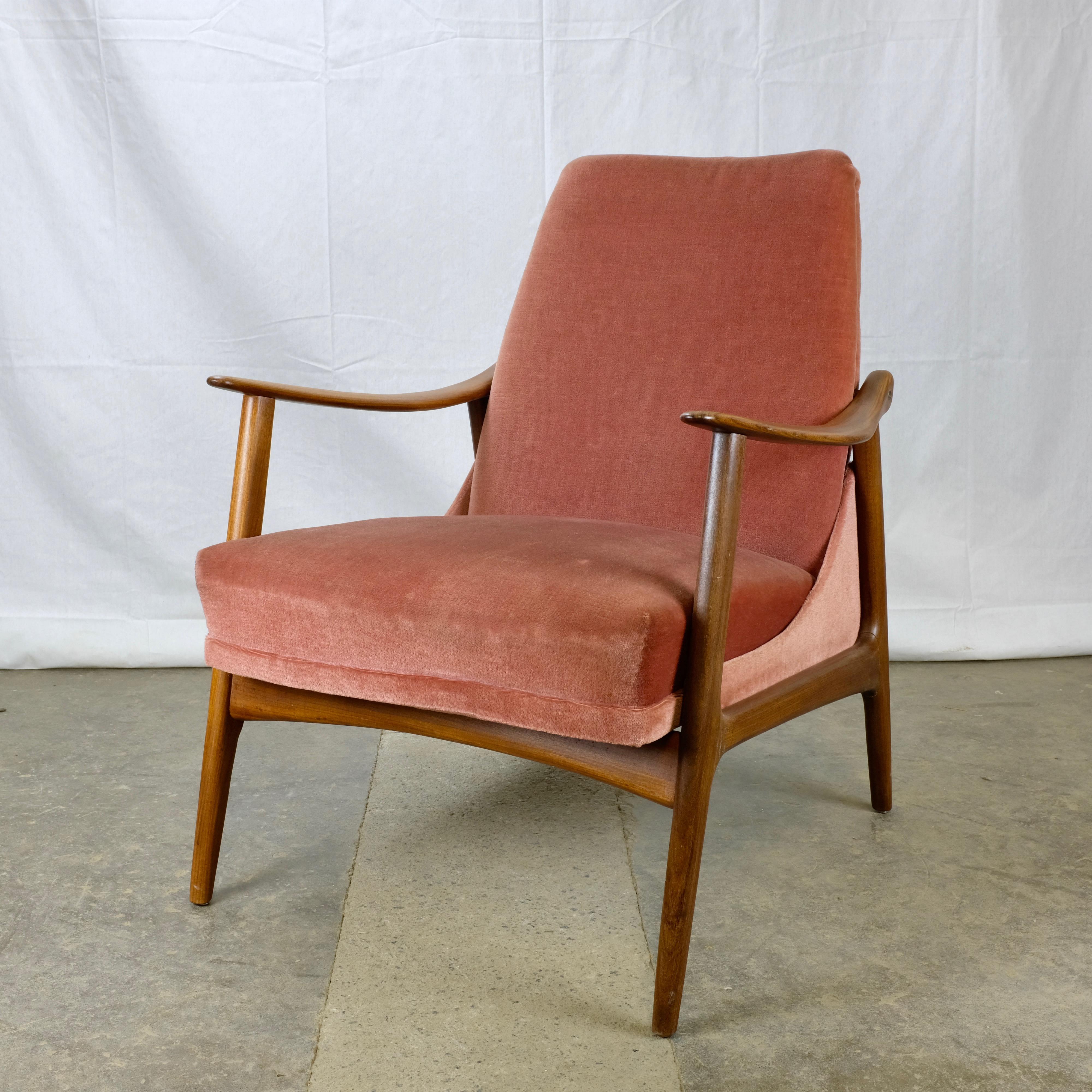 Danish teak armchair with solid teak frame and seat and back upholstered in a dusty rose velour.

The gracefully sloping armrests and angled legs give the chair a dynamic posture typical of Danish Modern furniture, while the soft velour upholstery