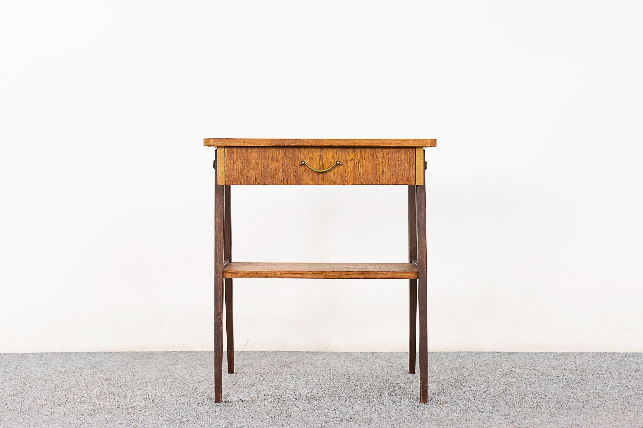 Teak mid-century bedside table, circa 1960's. Veneer case with contrasting splayed legs. Sleek dovetailed drawer and handy shelf! 

Please inquire for remote and international shipping rates.