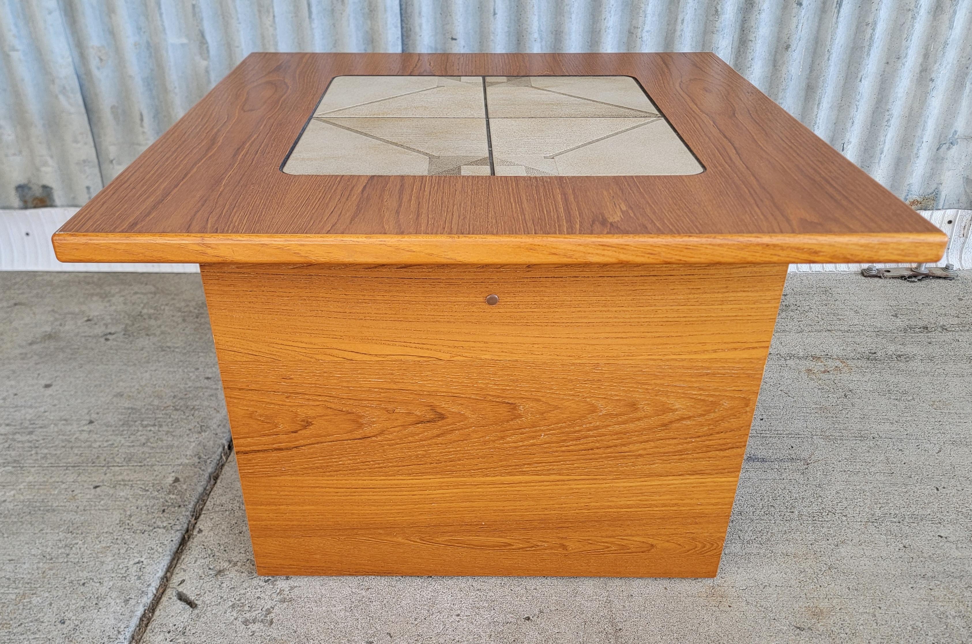 Teak Danish Modern end table with a geometric pattern ceramic tile top.  Circa. 1970's

27.5 inches wide.
27.5 inches deep.
19 inches high.