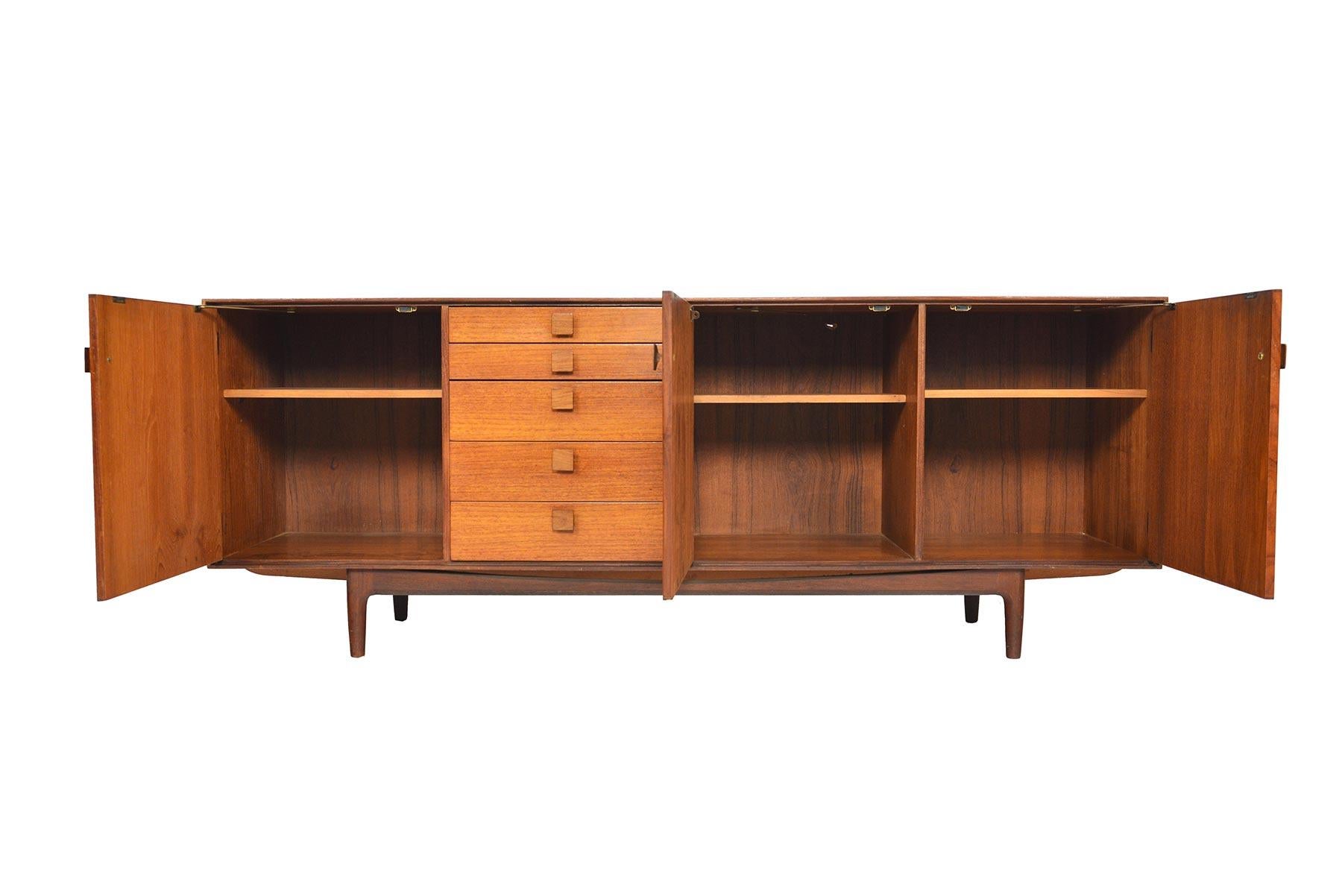 This Classic midcentury credenza was designed by Ib Kofod-Larsen for G Plan’s ‘Danish Range’ in 1961. Crafted in teak with handsomely refined lines, a bank of five drawers bear the designer’s signature square pulls in solid afromosia. Three doors on