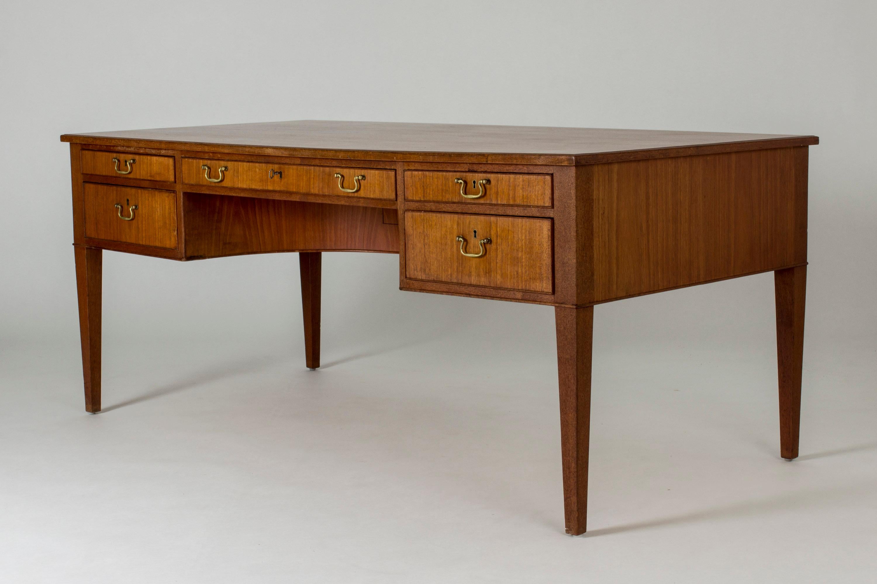 Elegant, spacious teak desk with brass handles by Frits Henningsen. The leg space is formed as an arch and in the deepest part, a secret compartment is hidden. It opens when the middle drawer is pulled out. Very nice attention to detail.