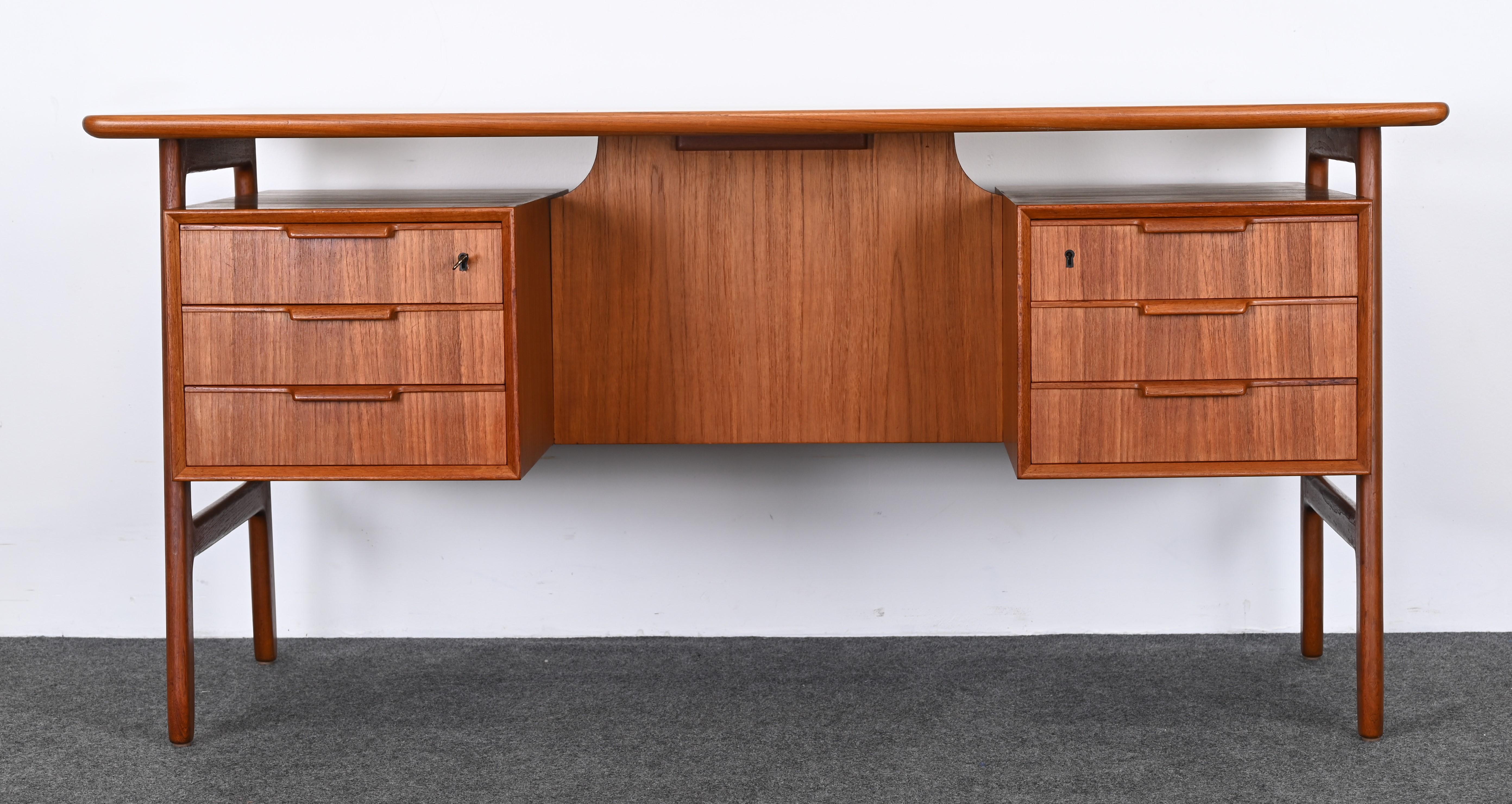 A sculptural Mid-Century Modern Danish teak desk designed by Gunni Omann for Omann Jun Mobilfabrik, 1960s. This Scandinavian desk has great design and proportions, as well as functionality with ample storage. Would work well in an apartment or any