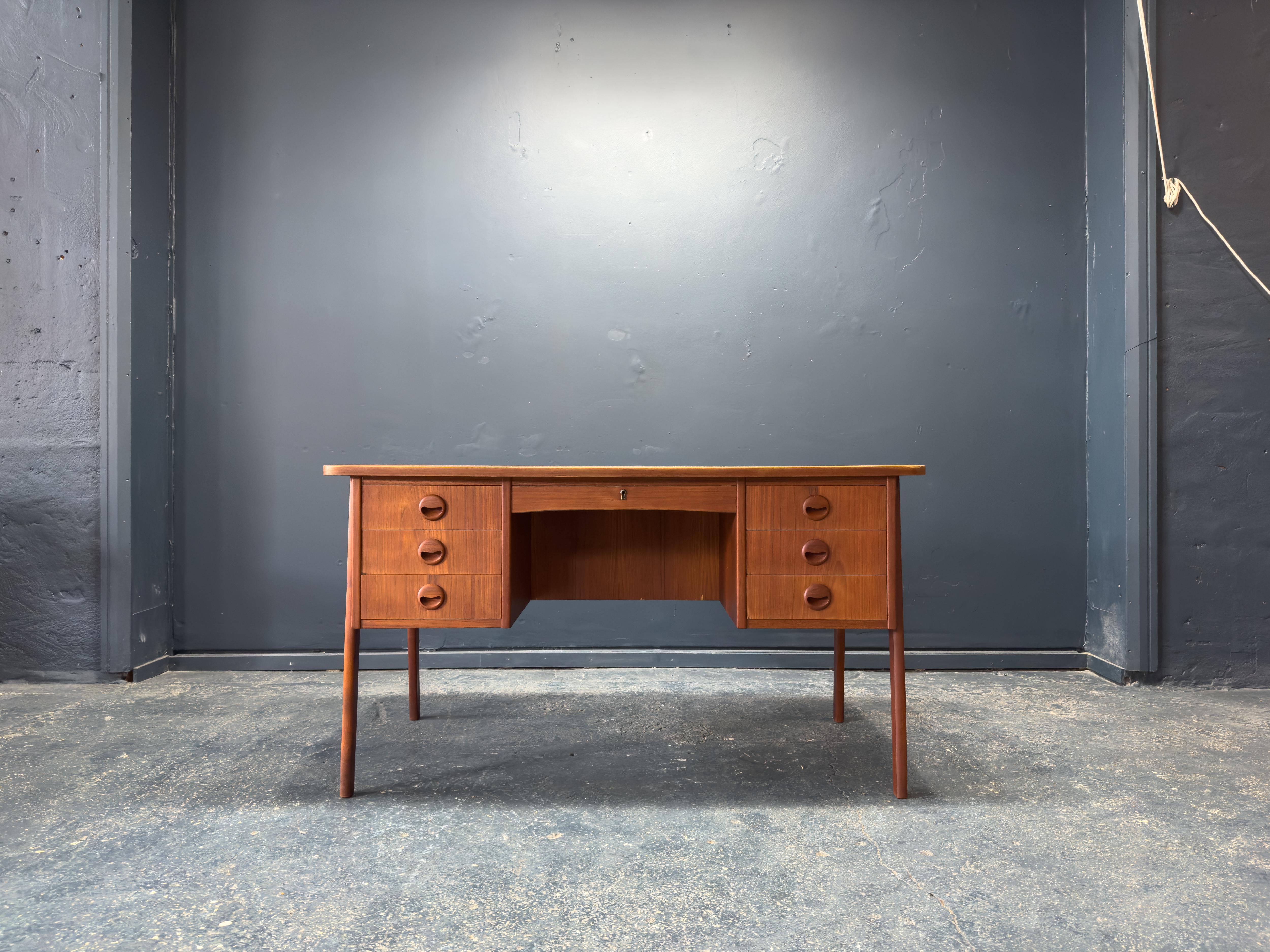 Questa scrivania in teak di metà secolo esemplifica il classico design scandinavo, offrendo una miscela armoniosa di eleganza, funzionalità e artigianalità. Le sue linee pulite e le proporzioni raffinate sono esaltate dal calore e dalle venature