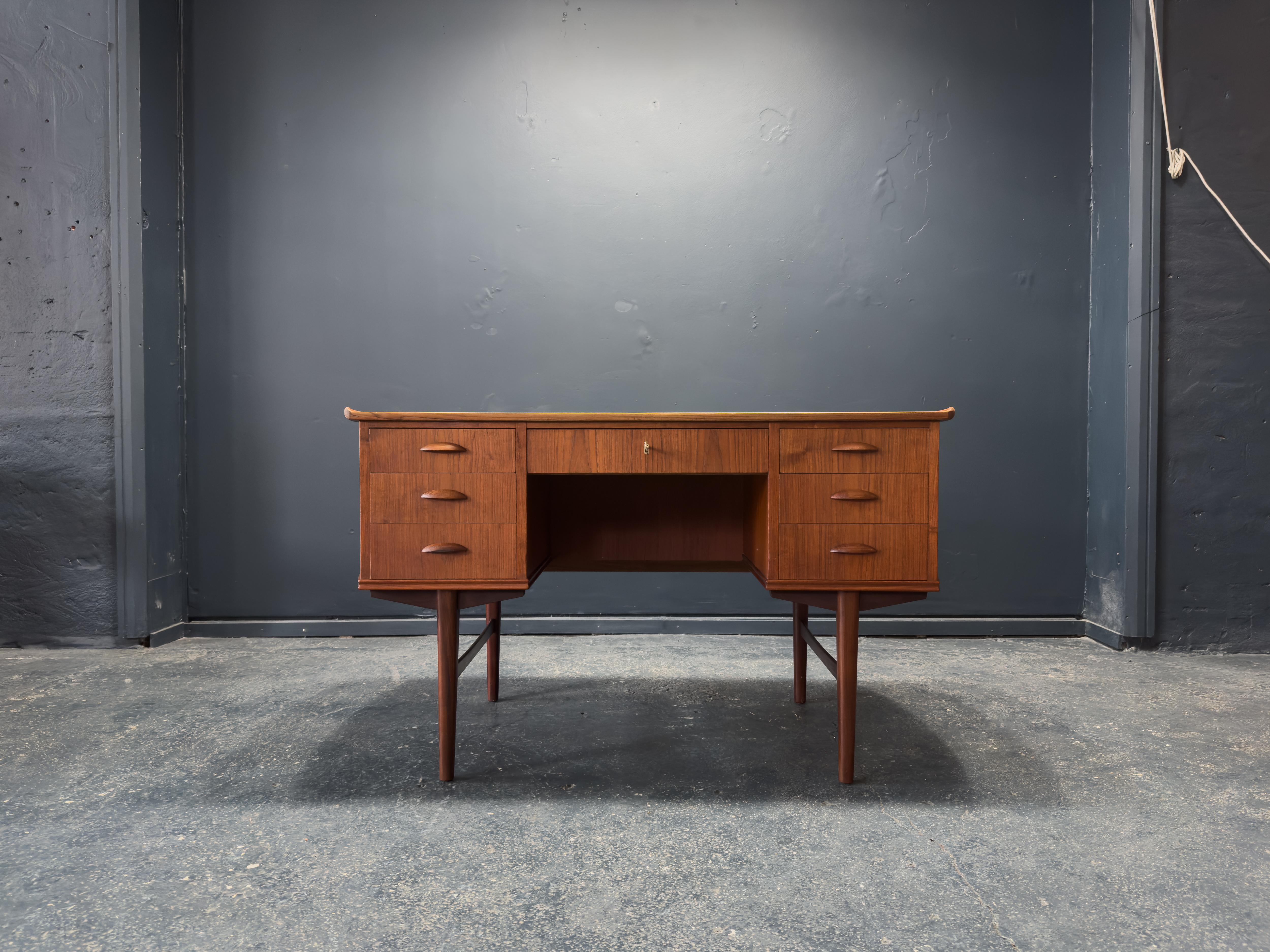 Questa scrivania vintage in teak combina forma e funzione con uno stile senza sforzo. Realizzata in teak con una ricca venatura, la scrivania presenta una silhouette equilibrata e simmetrica con sei cassetti - tre per ogni piedistallo - che offrono