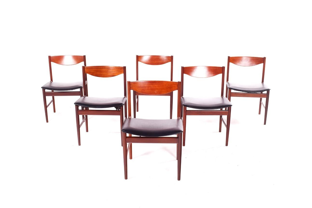 This set of six teak dining chairs designed by the Danish designer Ib Kofod-Larsen as part of the Danish range for G-Plan in the 1960s. The frames are made of teak and the seats are upholstered in black leather. Ergonomic curved back and slim