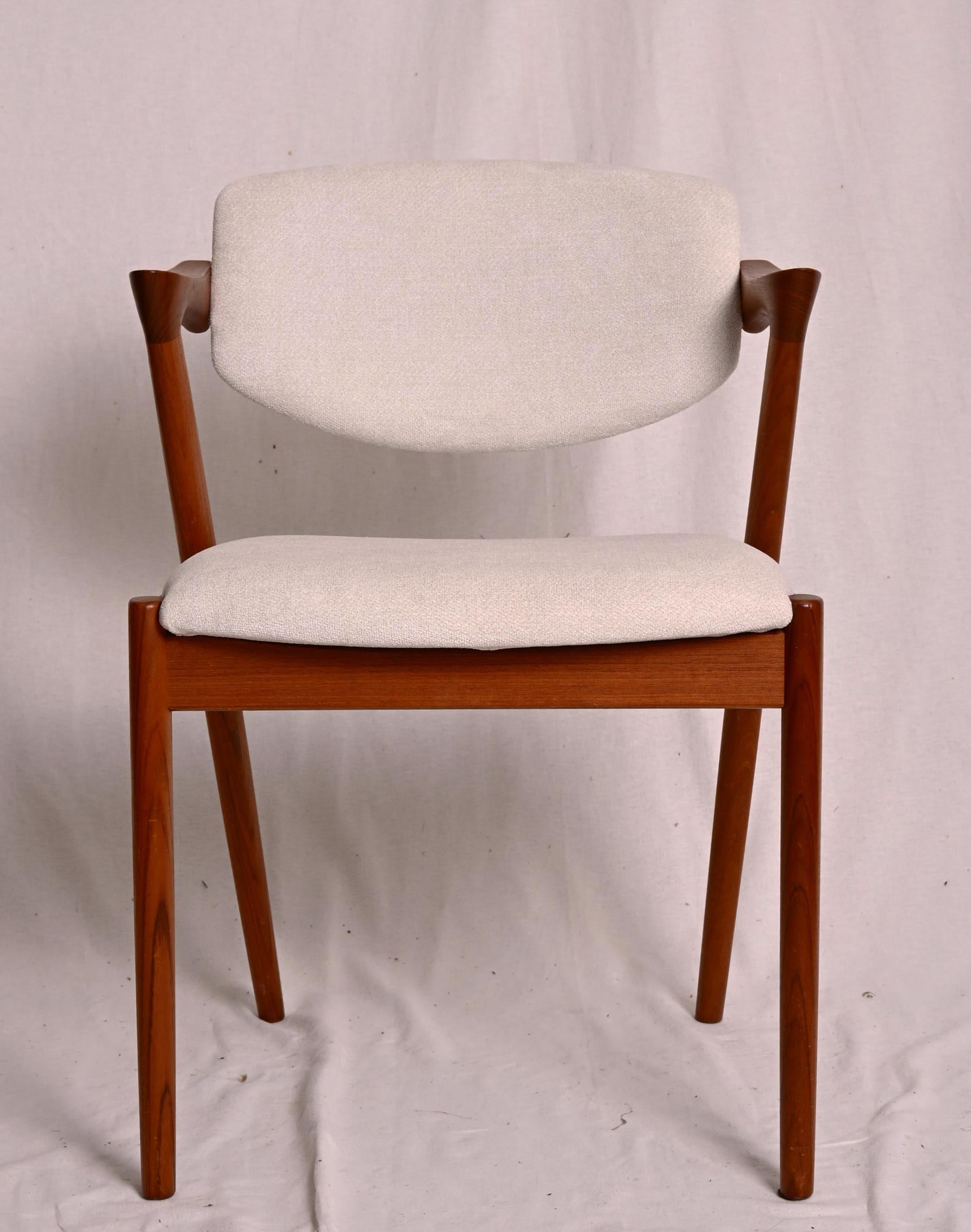 Sillas de comedor, modelo 42, diseñadas por Kai Kristiansen y fabricadas en Dinamarca por Schou Andersen Møbelfabrik. Las sillas son de teca maciza, con patas cónicas, reposabrazos curvados y tapicería nueva. Buen estado vintage. 
Precio por silla,