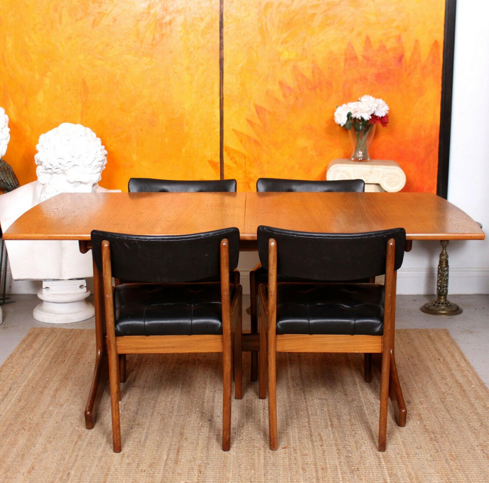 An impressive mid-20th century five piece teak dining suite by Vanson.

The dining table - extending by way of drawer leaf mechanism - raised on shaped legs united by stretchers. The chairs with the same angular shaped form.

England, circa
