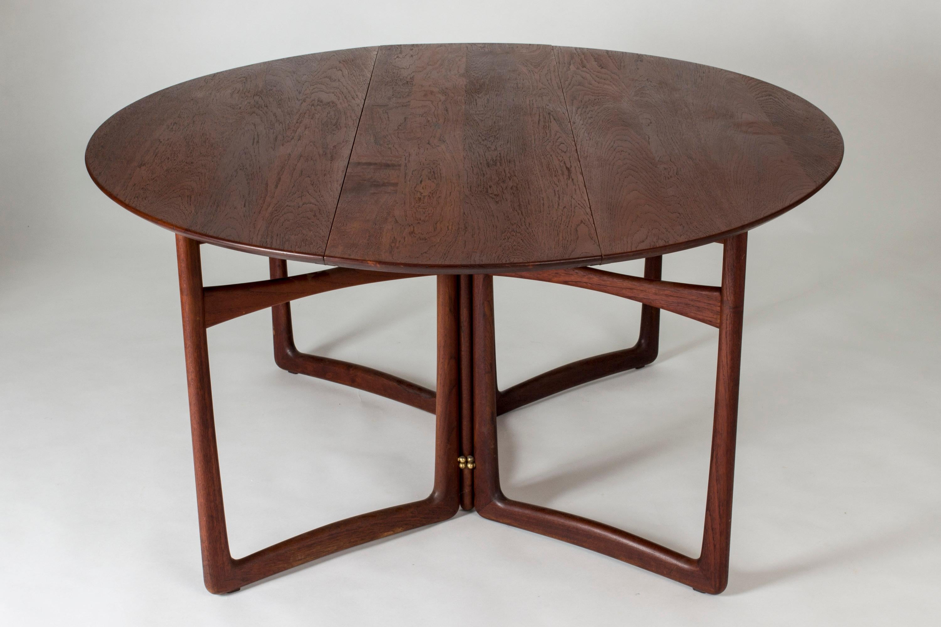 Stunning, sculptural teak drop-leaf dining table by Peter Hvidt and Orla Møllgaard. Beautiful oval shape and legs in the shape of five joined, sculpted rectangles. Beautiful teak woodgrain.