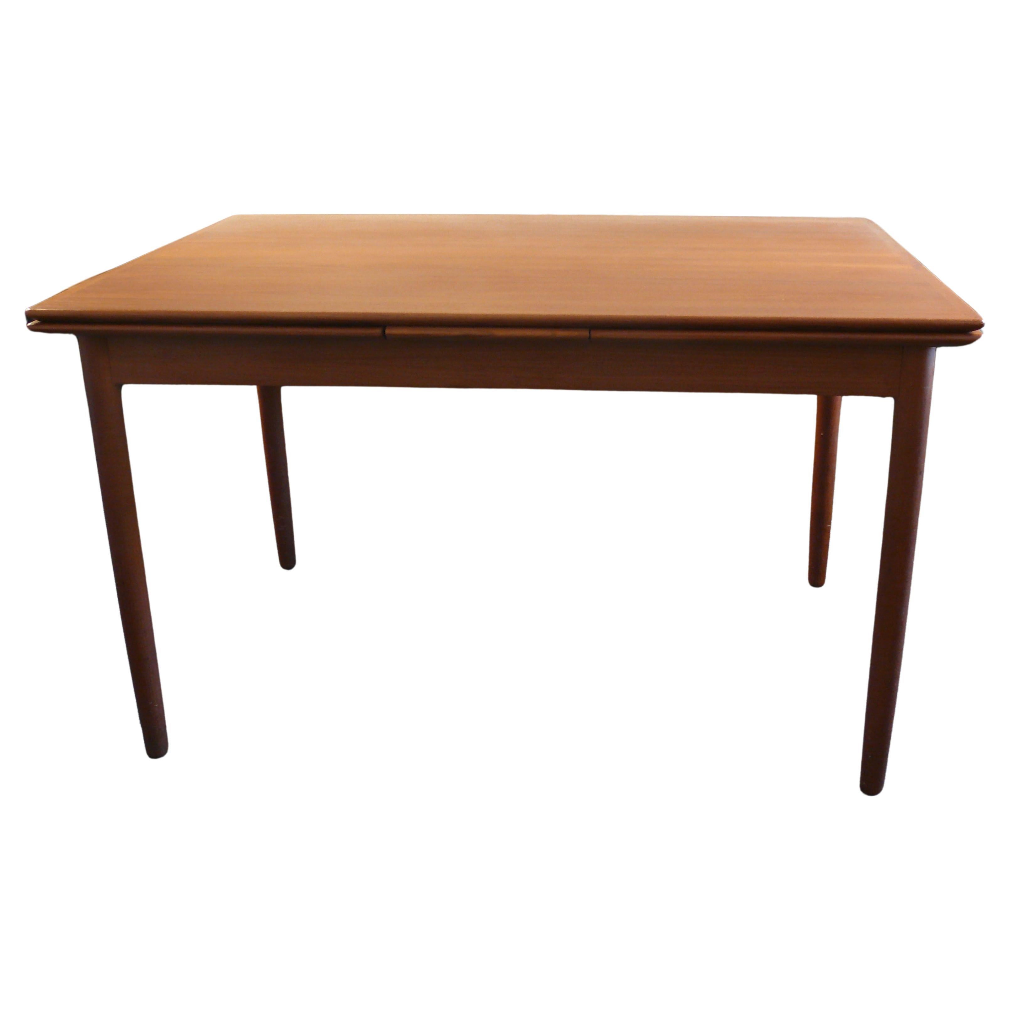 High-quality, extendable teak dining table, Denmark 1960s. A beautiful piece of design history of Nordic design from the 1960s. The table tops have rounded solid wood edges and veneered surfaces. The table can be pulled out both left and right, the