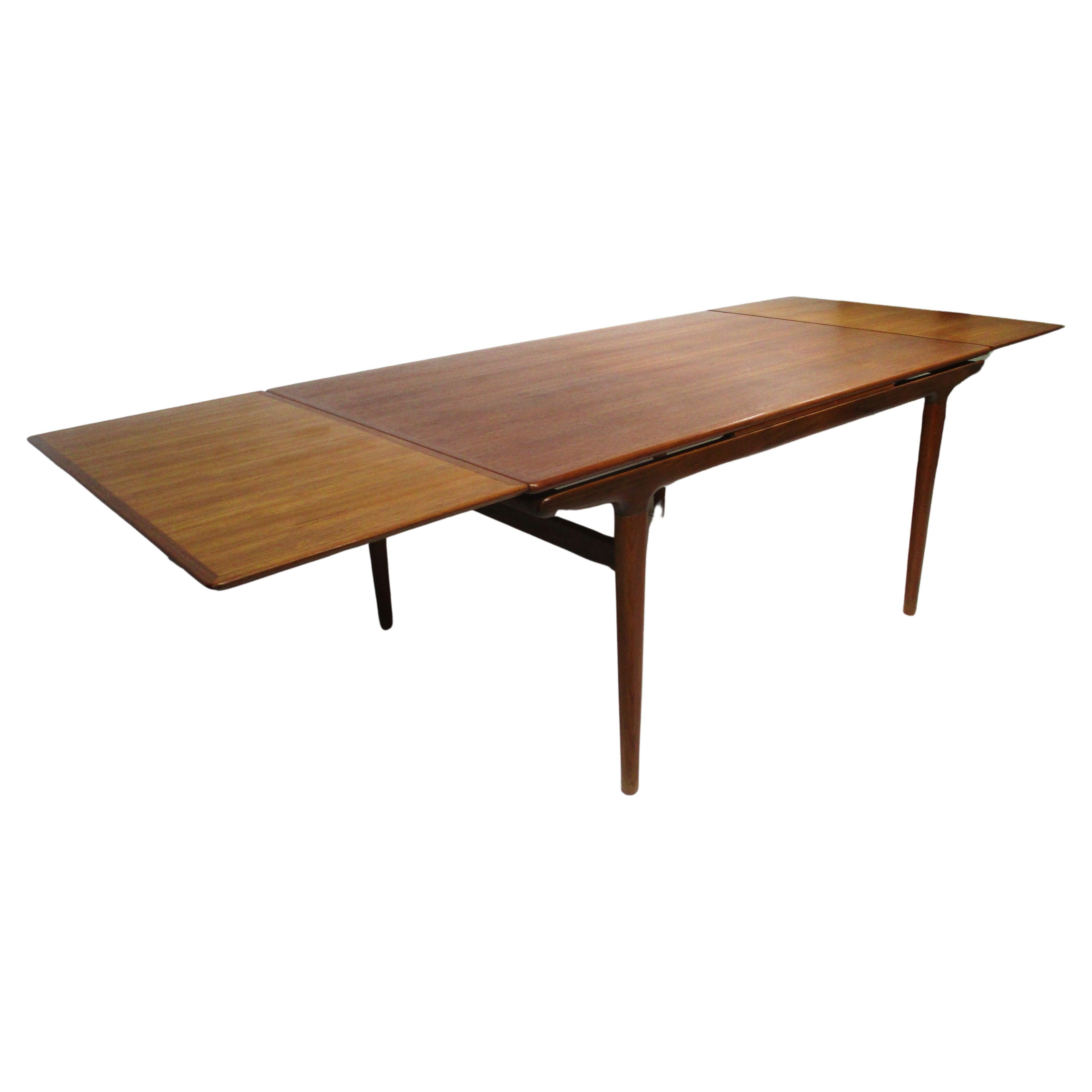 A very well crafted early Mid Century teak wood dining table with two 19.75