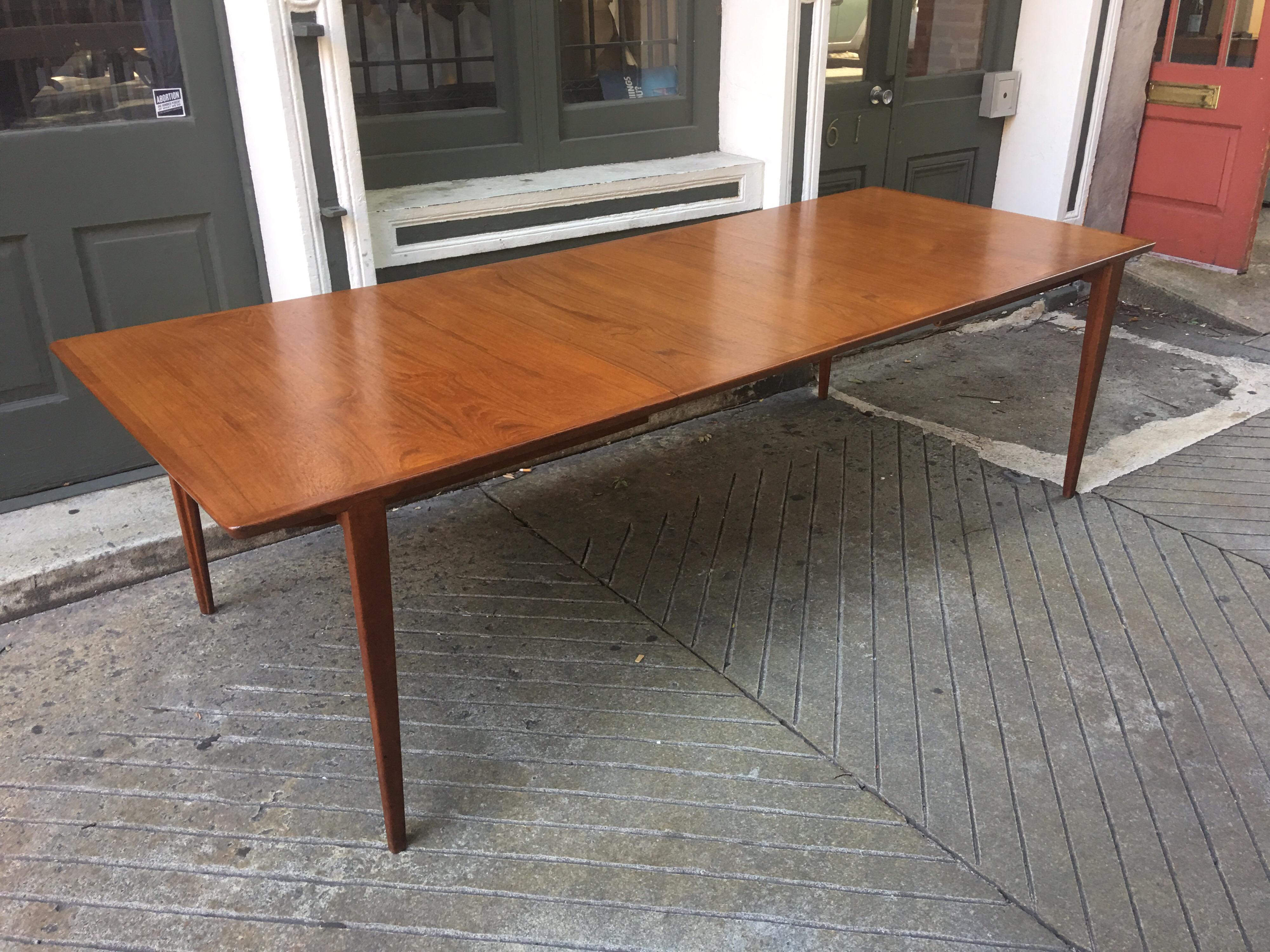 1960s teak dining table with 2 leaves. Leaves can be stored in table. Nice simple lines give this table a sleek appearance! Each leaf adds 17