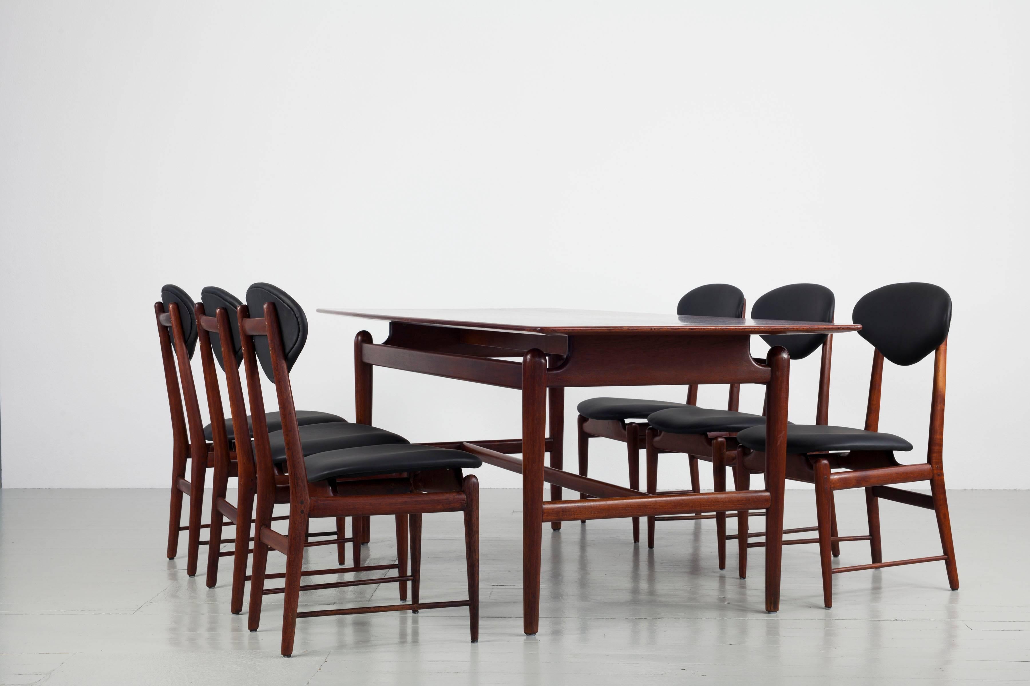 This set of six dining chairs was made in Italy in the 1960s. The chairs are made of glossy lacquered teak and the upholstered surfaces are reupholstered in black leather. The special design element of these pieces is undoubtedly the floating seat
