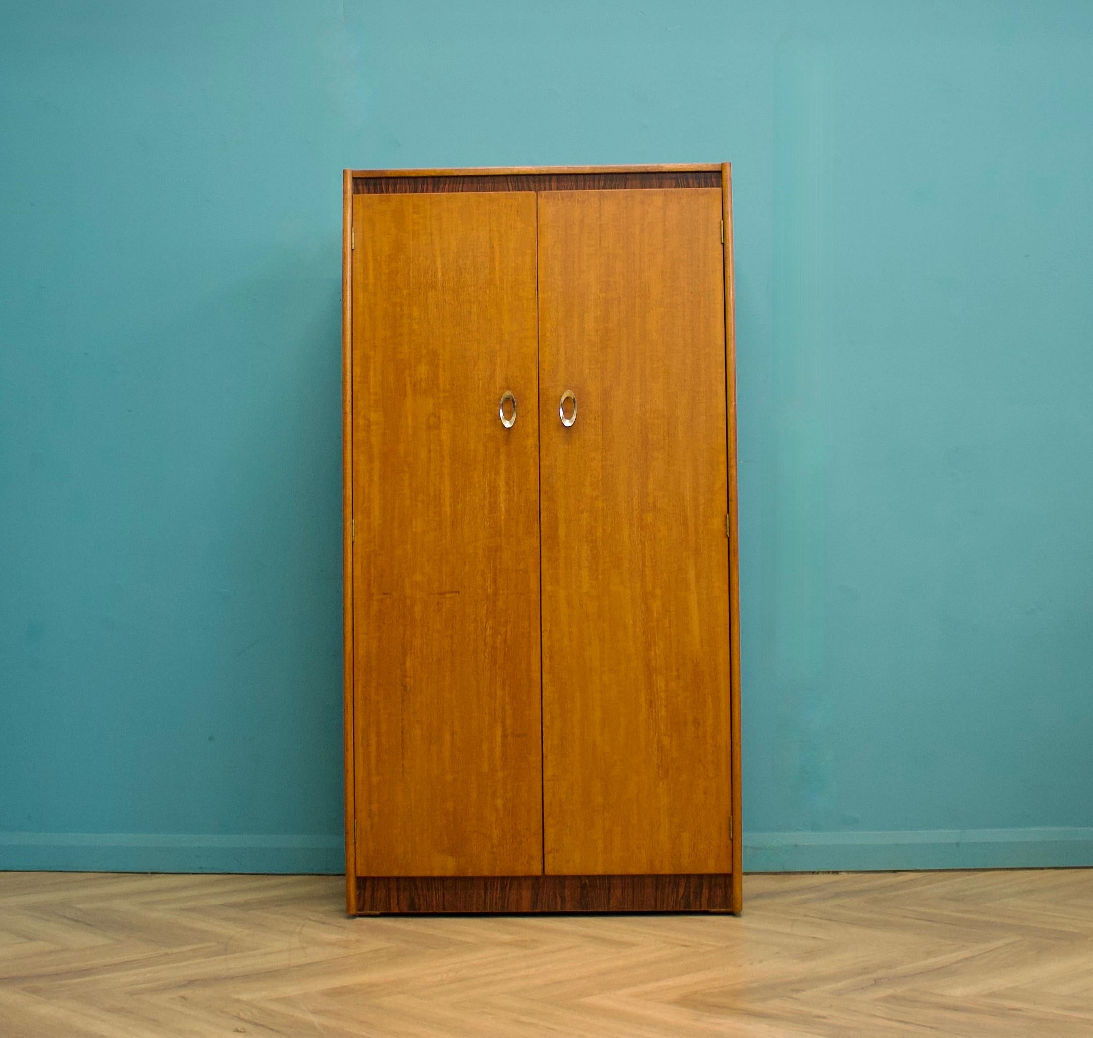 A freestanding double door teak wardrobe 
Made during the 1960s
 
Fitted out with a clothes rail
