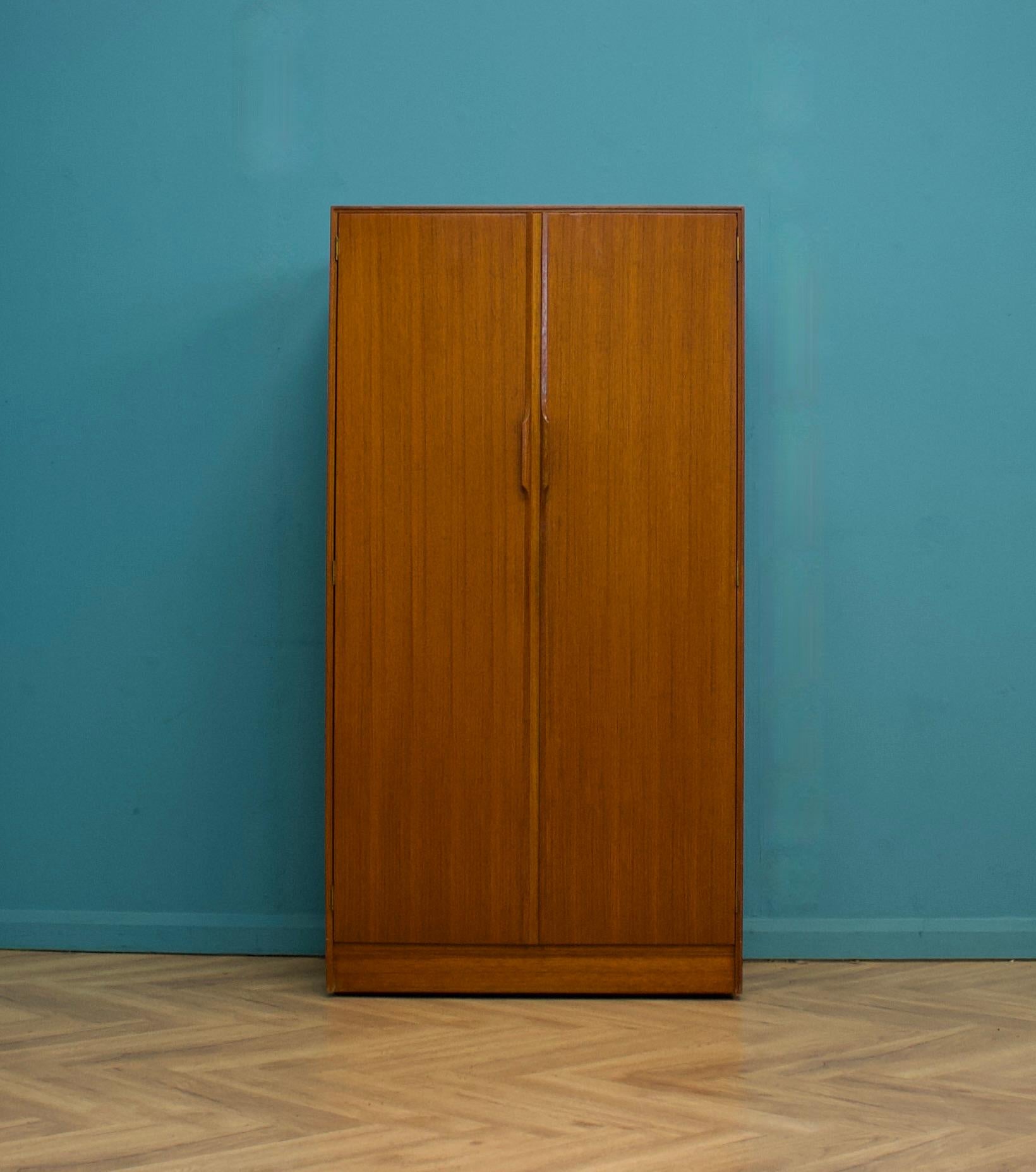 A freestanding double door teak wardrobe from Austinsuite
Made during the 1960s

Fitted out with a clothes rail, shelves and drawers
The style of this wardrobe is quite minimalist - with it's clean lines

This wardrobe will flat pack

