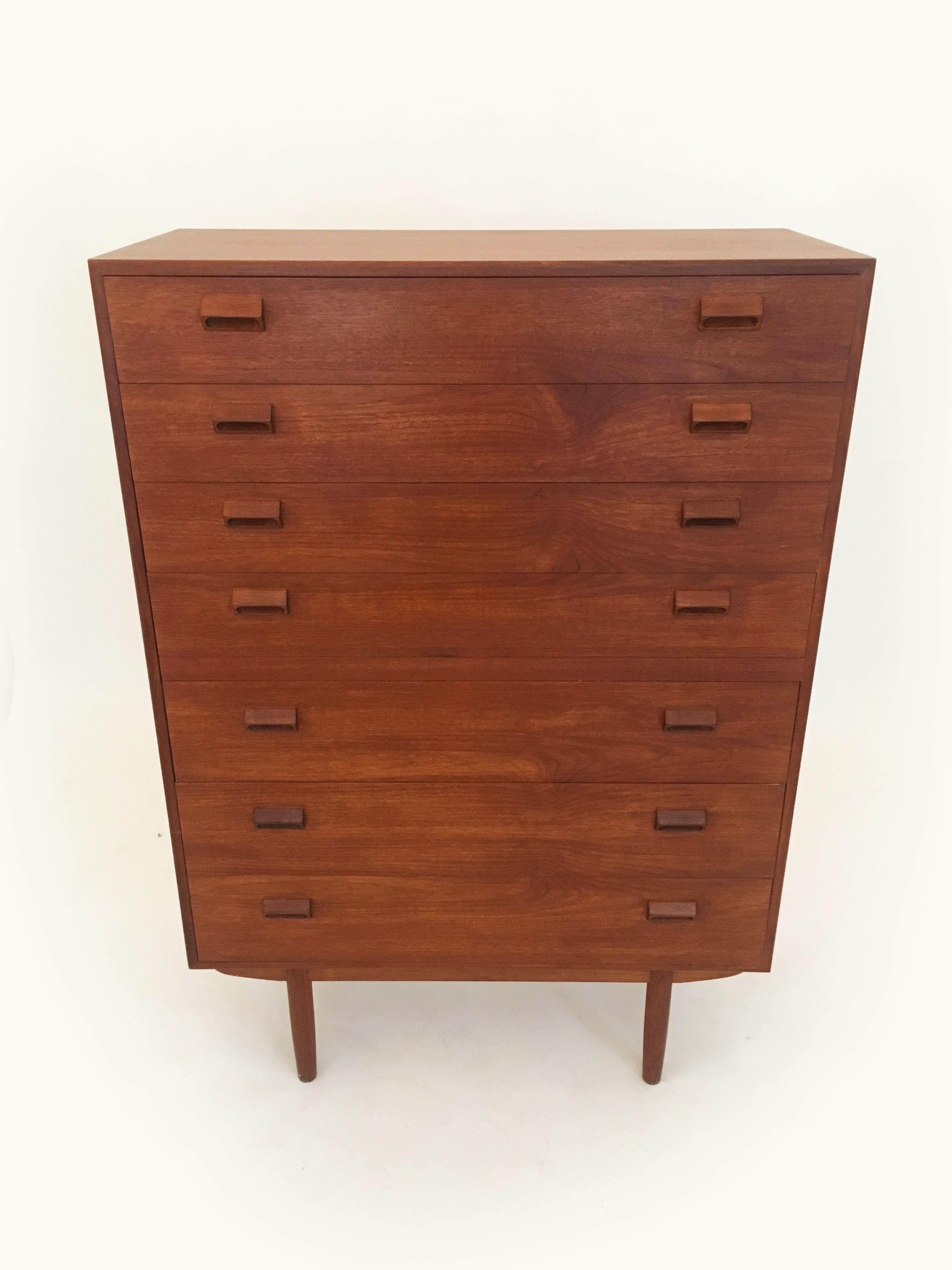 Teak dresser by Borge Mogensen for Neils Vodder, Denmark 1960s. A tall seven (7) drawer dresser or chest of drawers designed by Borge Mogensen. Dresser is constructed of solid teak wood with integrated wood handles on an oak base with tapered dowel