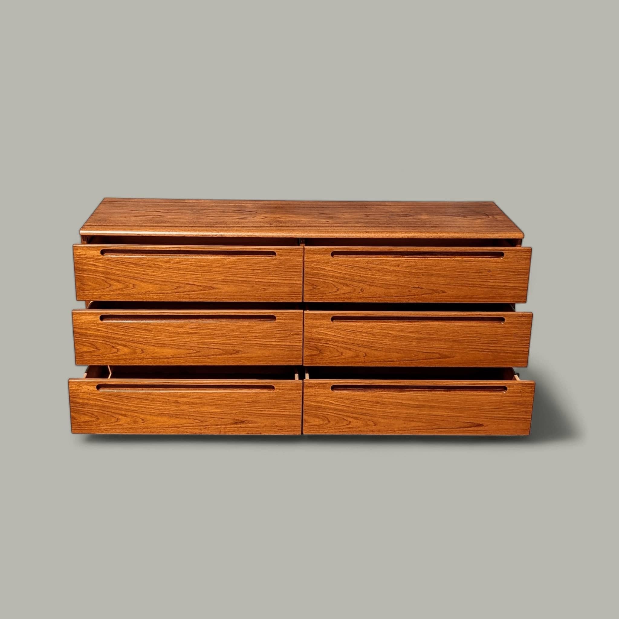 This stunning vintage dresser is a true embodiment of mid-century modern design. Crafted with exquisite attention to detail, it boasts a sleek and minimalist silhouette that exudes timeless elegance. The dresser's exterior is adorned with a rich
