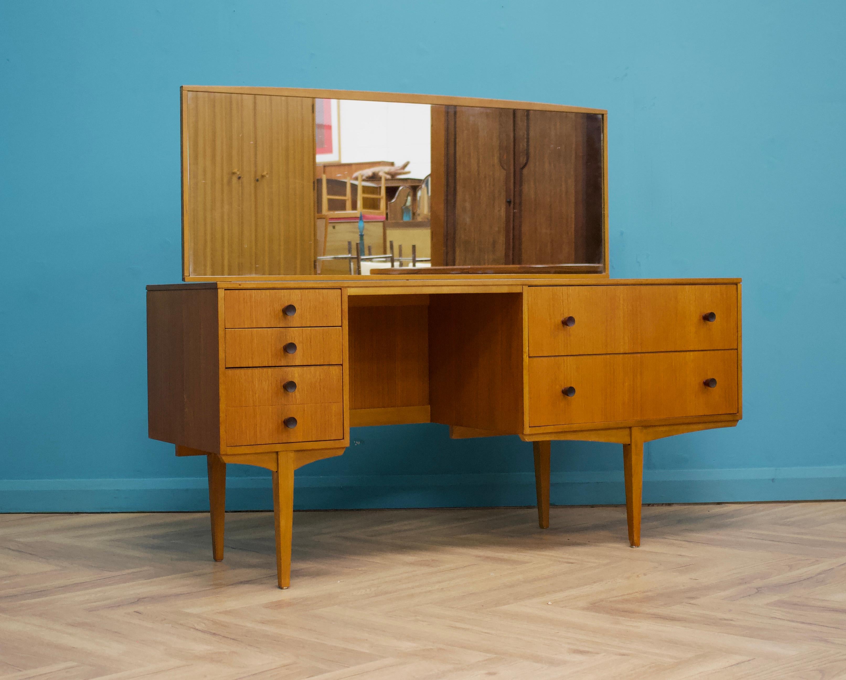 A mid century teak dressing table
Featuring five drawers and a tilting mirror
Height to the top of the mirror 115 cm